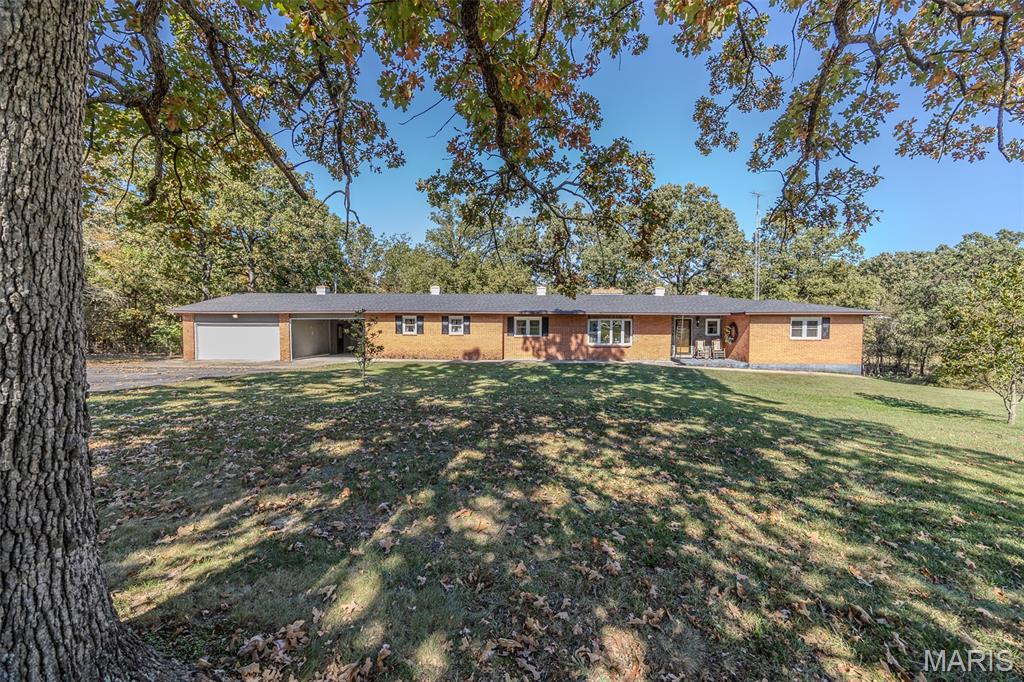 Classic Charm That Never Fades! This sprawling all-brick beauty has been loved by just one owner since the day it was built — and it shows! Featuring a new roof, new windows, and 4 spacious bedrooms with 2.5 baths, this home offers so much room you might just get lost exploring. Step inside and discover parquet wood floors, a double-sided brick fireplace, and a timeless eat-in kitchen that flows into the formal dining room and home office/library. The expansive family room is perfect for gatherings, while the quaint sitting room off the kitchen steals the show with its wood-beam ceiling and cozy fireplace. Set on 2.3 park-like acres, the property includes an attached garage and carport, plus a detached shop that’s truly one-of-a-kind — complete with bathroom hook-up, office space, and an impressive built-in gun safe. Classic, comfortable, and impeccably cared for — this one-of-a-kind family property won’t last long!