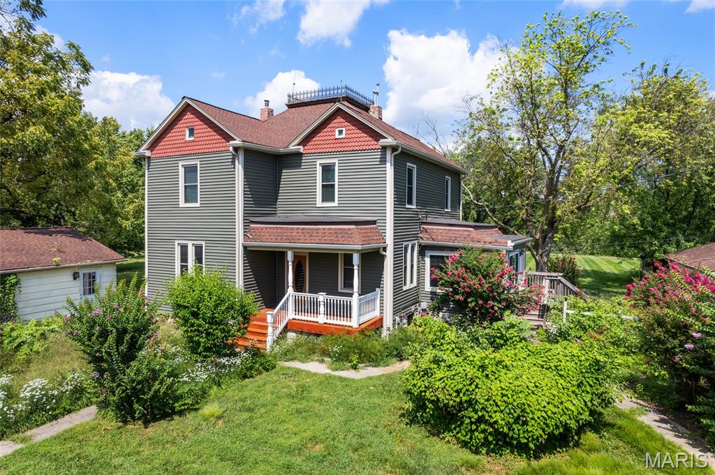 Once in a lifetime Opportunity to own a piece of O'Fallon history. This circa 1905 Victorian farmhouse is situated on 2.25 gorgeous acre in the heart of Ofallon.
The character is incredible with original hardwood floors, rich dark millwork,  and crown moldings. Walking up to the residence a beautiful covered front porch welcomes you. As you enter the home a formal living room with stunning sliding wood doors greets you. The living room flows to a main floor bedroom, most likely a former parlor. In the rear of the main floor you will find a large kitchen with gas cooktop, island, double oven, and ample cabinet space. There is also a large main floor dining room and main floor laundry. A clawfoot tub bath completes the main level. A stunning staircase leads you upstairs to 3 bedrooms,sitting room and full bath. The wood floors and woodwork are beautifully preserved. A 3rd staircase leads to a large attic area that could be converted into an artist studio or loft. There is an additional detached workshop on the grounds with 2 rooms and plumbing, as well as a detached garage. This one of a kind estate is just seconds from Fort Zumalt North High School, and Hwys 79 and 70.