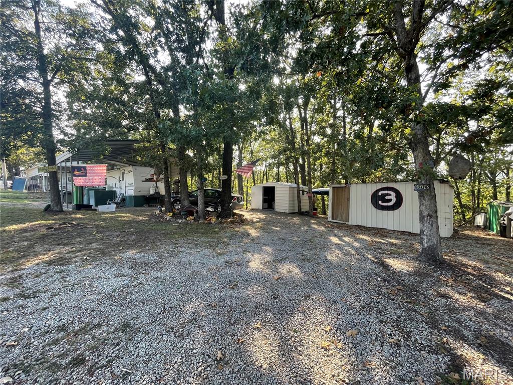 WHO LOVES TO FISH???  This sought-after Goose Creek Lake location offers two buildable lots with electric already on the property, giving you the perfect blank slate for a weekend getaway, camper setup, or future permanent home! Located within walking distance of one of the community’s larger fishing ponds, parks, and campground areas, you’ll have outdoor recreation right across the street. The property is already set up and ready to enjoy, featuring a 30 x 40 awning—perfect for bringing your camper and settling in while you plan your next move. Three storage sheds, including 10x10, 16x16, and 9x8, provide plenty of room for lake toys, tools, and equipment. The property also features a small garden area and blueberry vines. From the back of the property, you can see the Big lake in the Fall & Winter month too. Spend your mornings or evenings walking around the fishing pond, or grab your fishing poles and enjoy the community’s many outdoor opportunities! Goose Creek Lake offers approximately 400 acres of gated lake-community amenities, including boat ramps, beach areas, parks, fishing, camping, and more. Whether you’re looking for a weekend escape or ready to build your dream lake home, these two lots are ready for you! Easy to show—cash buyers welcome & camper is negotiable. Seller is ready to see offers!