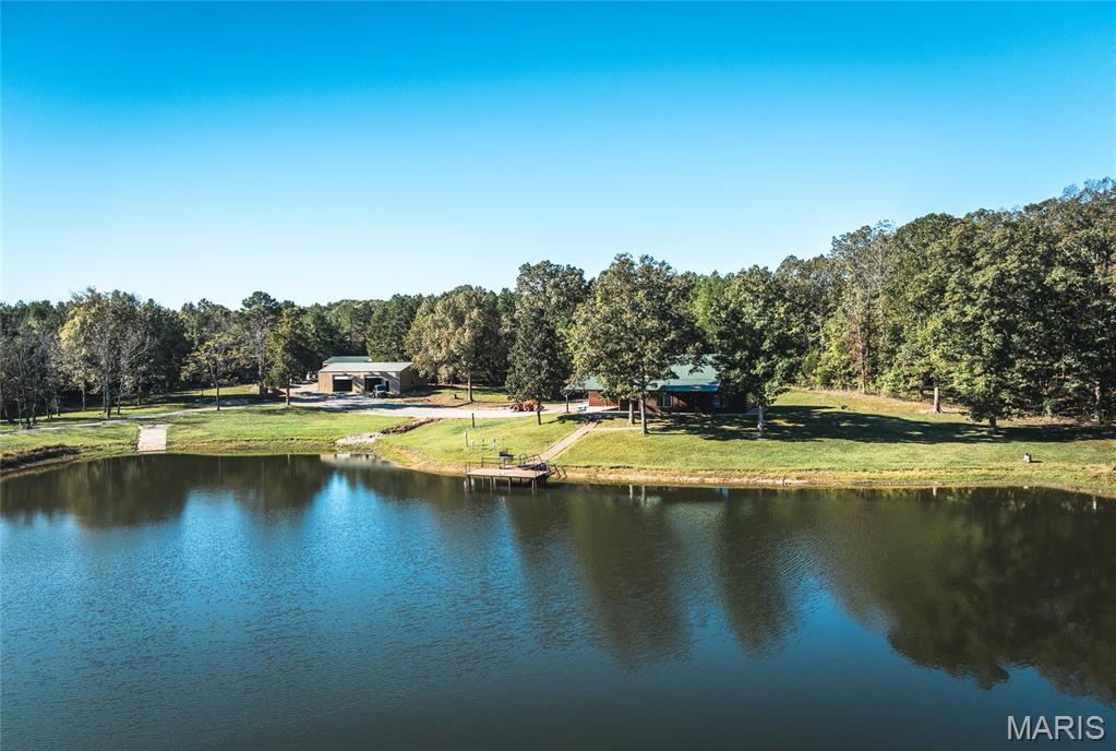 CLIFFS LAKE--A SPORTMANS PARADISE

Discover your own private retreat on this remarkable 210-acre property located just outside Fredericktown, Missouri. This one-of-a-kind estate combines natural beauty, privacy, recreation, and comfort in an unmatched setting. The land features a stunning 10-acre stocked lake with a private dock and boat ramp — the perfect spot to fish for crappie, bass, bluegill, and catfish or simply enjoy the peaceful view across the water.

A handcrafted red cedar log cabin rests near the lake, offering warmth and character with its rustic charm and stone flue wood-burning furnace. The cabin provides a comfortable getaway for weekends or extended stays and blends beautifully with the surrounding forest and rolling hills. Power and utilities are already in place, including underground electric service, a deep well, and a septic system — offering the convenience and functionality needed for year-round use.

Outbuildings include a large 30x60 shed equipped with power and water, ideal for storing equipment, boats, and ATVs, plus a separate machine shed for tractors or additional storage. The property has an excellent internal road system, making it easy to access all areas — from the open fields and food plots to the wooded ridges and the lakefront.

This land has been carefully managed and enjoyed by the same family for more than 25 years as a dedicated deer, turkey, and fishing property. The established food plots and natural cover create an ideal habitat for wildlife. Deer and turkey populations are abundant, and the layout of the land provides excellent hunting opportunities in multiple locations. Whether you’re an avid outdoorsman, a conservation enthusiast, or simply looking for peace and privacy, this property delivers everything you could want in a recreational farm or weekend retreat.

The terrain offers a mix of food plots, mature timber, and scenic wooded draws, giving the land both beauty and versatility. With plenty of road frontage and several ideal building sites overlooking the lake and surrounding countryside, the possibilities are endless. Create your dream home, expand the existing cabin, or develop a family compound where generations can enjoy outdoor recreation together.

Other highlights include established internal trails and roadways throughout the property, making it easy to explore on foot, horseback, or ATV. Underground electric ensures clean, unobtrusive access to power, while the deep well and septic system support comfortable off-grid living. The large lake not only provides excellent fishing but also serves as a beautiful centerpiece for the entire property — a peaceful setting for boating, swimming, or relaxing by the water’s edge.

Properties of this size and quality are extremely hard to find. Whether your vision is a hunting lodge, private estate, or recreational getaway, this property offers everything in place to make it your own. With a proven history of exceptional deer and turkey hunting and fishing that has been enjoyed for decades, it’s ready for new memories to be made.

If you’re looking for a secluded property with water, wildlife, and all the amenities already established — look no further. This 210-acre Missouri retreat has it all: a 10-acre lake, a charming red cedar log cabin, multiple outbuildings, excellent infrastructure, and a pristine natural landscape ready to enjoy.