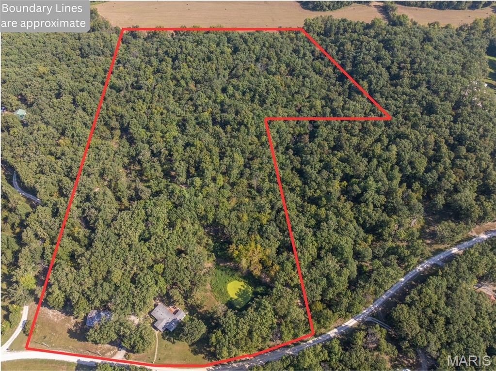 Welcome to the American dream. Hunt fish and play right where you live with this 23+/- acre wooded paradise! Located in Silex School District. Home on the property is 3 bedroom, 2 full bathroom, has an open floor plan, large wrap around back deck and is complemented by a 30x50 shop with concrete floors and electric. The property is beautiful, with steep draws, flat ridges and a bluff in the back for an amazing view of the valley behind it. Several trails are cut through the woods and the terrain makes it the perfect place to ride fourwheelers and side by sides. Big Lead Creek borders the property to the north and there is a good trail down to it to enjoy the water on a hot summer day. Several large deer have been harvested on this property and there are good clearings in the woods for food plots. There is also a pond behind the home that the seller recently rebuilt the dam on. Quarry road was recently paved and there is only a short strecth of gravel on Jerry Miller Ln. Selling as is