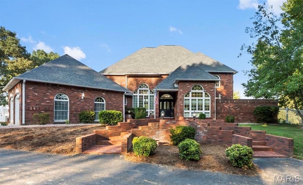 Welcome to this Benton beauty, where stately curb appeal, incredible space, and a beautiful setting come together on just under 2 acres. This impressive all-brick home offers over 5,000 total square feet, beginning with a grand circle drive, mature trees, new landscaping, and a fabulous fenced backyard made for enjoying every season.

Inside, the show-stopping family room soars two stories high with towering windows and a dramatic fireplace. The spacious kitchen is designed for gathering, featuring a center island, breakfast bar, casual eat-in dining, plus a separate formal dining room. A private main-level owner’s suite and dedicated home office add everyday convenience.

Upstairs you’ll find three additional bedrooms with 2 full baths, then continue up to an incredible bonus level… the perfect playroom, teen hangout, or flex space- with its own half bath.

The newly remodeled walkout basement feels like an extension of the home, complete with a wood-burning fireplace, full bath, and generous exercise/rec space. Fresh paint and updated lighting throughout give the home a beautifully refreshed feel.

Step out to the brand new covered patio or relax on the deck, enjoy the expansive fenced yard beneath mature trees, and take advantage of the peaceful subdivision pond and setting that Meyer Lake Estates has to offer. A rare combination of space, character, updates, all on an exceptional lot!