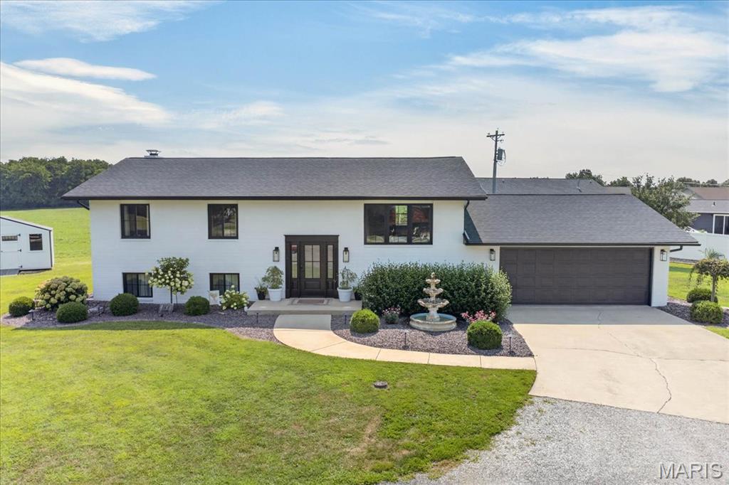 Welcome to this stunning, completely renovated 4-bedroom, 3-bath split-level home, perfectly situated on a beautifully landscaped 0.30-acre lot. With virtually every inch of the home updated inside and out, this move-in-ready property combines modern style, exceptional functionality, and outstanding outdoor living. The heart of the home is the gorgeous, newly remodeled kitchen featuring custom cabinetry, solid surface countertops, a striking herringbone tile backsplash, stainless steel appliances, and an oversized center island. The adjoining eat-in dining area flows seamlessly into the spacious living room, creating an open-concept design that's ideal for everyday living and entertaining. The finished lower level offers an impressive 26' x 20' recreation room centered around a beautiful masonry fireplace with a wood-burning insert. A convenient prep area with cabinetry and sink makes hosting family and friends effortless. This level also includes a fourth bedroom, half bath, spacious laundry room, bonus room perfect for a home office, gym, or hobby space, and a walk-up basement providing direct access to the oversized, finished two-car garage complete with built-in cabinetry and countertops. The private primary suite offers its own composite deck, where you can enjoy peaceful morning sunrises with coffee while watching deer and wild turkey roam the backyard. Step outside to your own backyard retreat featuring a spectacular 45' x 15' concrete patio with a pergola complete with a durable metal roof and ceiling fan—perfect for outdoor entertaining or simply relaxing. Additional exterior highlights include a new wrought iron fence, storage shed, extensive professional landscaping, and exceptional curb appeal. For added peace of mind, the roof was replaced in 2025 and the HVAC system in 2023. With quality updates throughout, generous living space, and an incredible outdoor setting, this exceptional home is truly one of a kind and ready for its next owners.