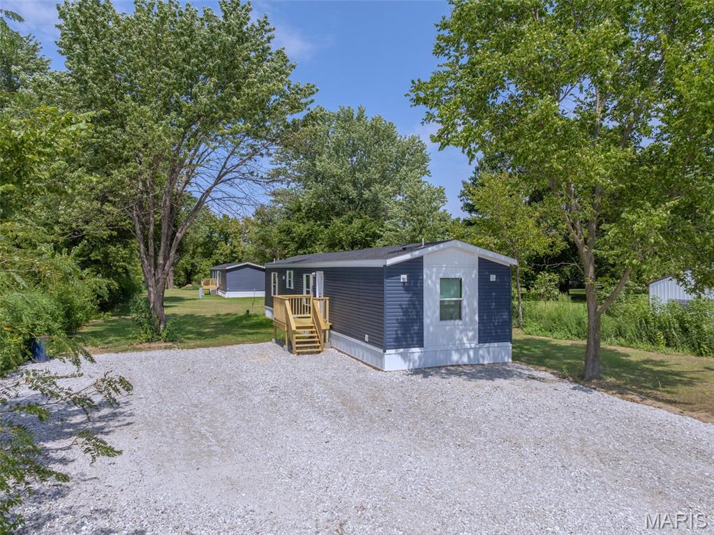 3 words you don't ever hear together, nice, new, affordable! Brand new 3 bedroom, 2 full bathroom manufactured home affixed to a city lot in the quiet country town of Truxton, Missouri. Home comes stocked with a stove, overhead microwave and refrigerator making it move in ready. Master bedroom features a walk in closet and en suite bathroom with step in shower and is big enough to fit a king sized bed. Galley style kitchen is upgraded with extra cabinet and counter space giving you the perfect place to prepare a meal. The living room gives you enough space for a sectional, recliner and entertainment center but with the front porch, shaded lot and farm field view, you won't be spending any time inside! The lot it sits on is level and ready to build a shop or shed on with ease. Located just a few miles from Highway 70 and not far from Warrenton, Hawk Point and Troy. Connected to a shared well and public sewer. Gutters getting installed in the next couple of weeks. Extra wall panels and trim in living room will be removed prior to closing unless specified by buyer. Agent Owned