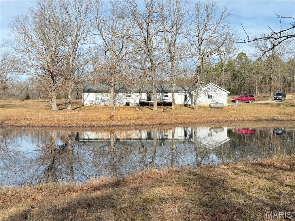 Ranch-style home on 48.70 acres just minutes from town!
This 3-bedroom, 1-bath home features an open floor plan ideal for comfortable country living. The spacious living room includes a wood-burning fireplace and flows seamlessly into the kitchen and dining area. The kitchen offers a center island, ample cabinetry, and a window overlooking a scenic pond and wooded views.

Three nicely sized bedrooms and a full bathroom are located on the south side of the home. On the north side, a laundry room leads to a versatile bonus room—ideal for an office, hobby space, or small workshop—with direct access to the oversized two-car attached garage.

The 48.70-acre property provides excellent accessibility with county road frontage on two separate county roads, including approximately 984 yards on one road and 514 yards on the other. The acreage is perimeter-fenced with portions cross-fenced and is primarily wooded with a large section of open ground. A fenced area includes a small barn with access to a second pond. Additionally, a 30' x 40' building with a gravel floor and electricity offers great storage or workshop potential.

Plenty of open ground surrounds the home, providing space for gardening, outdoor recreation, and entertaining—or simply relaxing and enjoying the park-like setting and pond. While the home could benefit from some updating, it offers a wonderful opportunity to experience peaceful country living with room to make it your own.