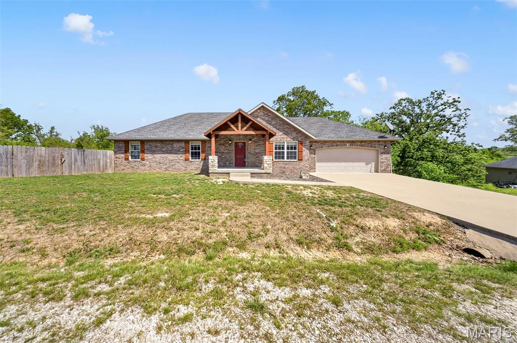 Welcome to this stunning 4 bedroom, 3 bathroom home in St. Robert, ideally located just minutes from Fort Leonard Wood and all the conveniences of town. From the moment you arrive, the inviting timber frame front porch sets the tone for the warmth and character found throughout the home. Step inside to an impressive living room featuring elegant tray ceilings, creating a spacious yet cozy atmosphere. The kitchen is designed for both function and style, offering brand new stainless steel appliances, breakfast bar seating - barstools included, and easy access to the dining area, which showcases its own tray ceiling and a beautiful chandelier. A conveniently located laundry area sits just off the kitchen. The primary suite is a true retreat, complete with tray ceilings, a generous walk-in closet, and a private ensuite bathroom featuring a double vanity and walk-in shower. Specialty ceiling fans—including a smart fan operated by the iLink app—add modern comfort and efficiency throughout the home. The fully finished walk-out basement expands your living space with a second family room, an additional bedroom, and full bathroom, plus a dedicated workout room (gym equipment included) and extra storage. This home also offers the potential for a 5th bedroom. Enjoy peace of mind with a commercial-grade HVAC system, a built-in Vivint home security system, and two 50-gallon water heaters. Outside, the fenced backyard and covered deck provide the perfect setting for relaxing or entertaining. Garden enthusiasts will love the large, established garden area featuring strawberries, blackberries, blueberries, tomatoes, potatoes, cucumbers, raspberries, peppers, garlic, lettuce, onions, broccoli, and even fruit and nut trees, including apple, peach, almond, and walnut. The adorable poultry coop & resident chickens are negotiable! With thoughtful upgrades, generous living space, and a prime location, this home truly has it all—schedule your private showing today!