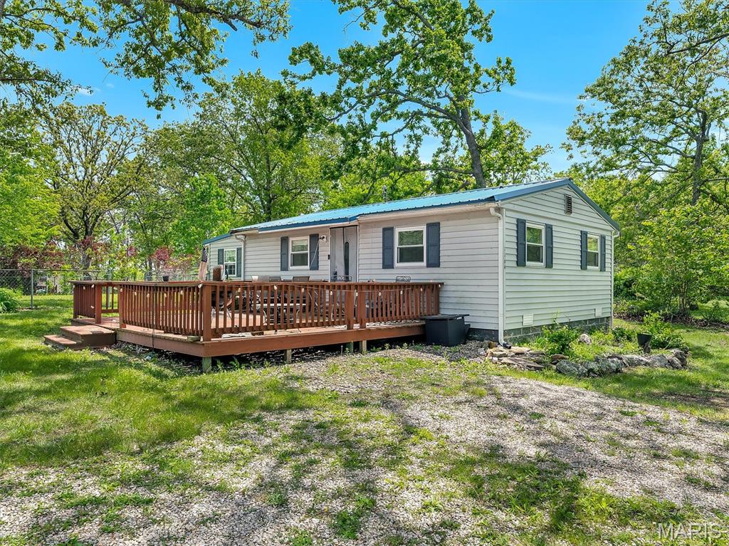 Escape to your perfect getaway in the highly sought-after Indian Hills Lake subdivision! This charming, recently updated cottage is ideally located just a short distance from the lake, offering both relaxation and recreation. A welcoming circle driveway sets the tone as you arrive. Step in from the spacious deck into a bright, open floor plan featuring an eat-in kitchen with stainless steel appliances, additional dining space, and a seamless view into the cozy living room—perfect for entertaining or unwinding. The home includes a generously sized bathroom with a tub/shower combo and convenient access to the bedroom. Situated on two lots, the property offers exceptional flexibility—whether you’re dreaming of an addition, a second home, or simply enjoying the extra space. The fenced yard and two storage sheds provide added functionality, while a newer roof and oversized carport add peace of mind and convenience. As part of the gated Indian Hills community, you’ll enjoy access to a 326± acre lake, sandy beach with playground, pickleball and tennis courts, basketball courts, clubhouse, and a full-service marina. Whether it’s fishing, boating, water skiing, kayaking, or swimming, this community truly has it all. Don’t miss your chance to own a slice of lake life!