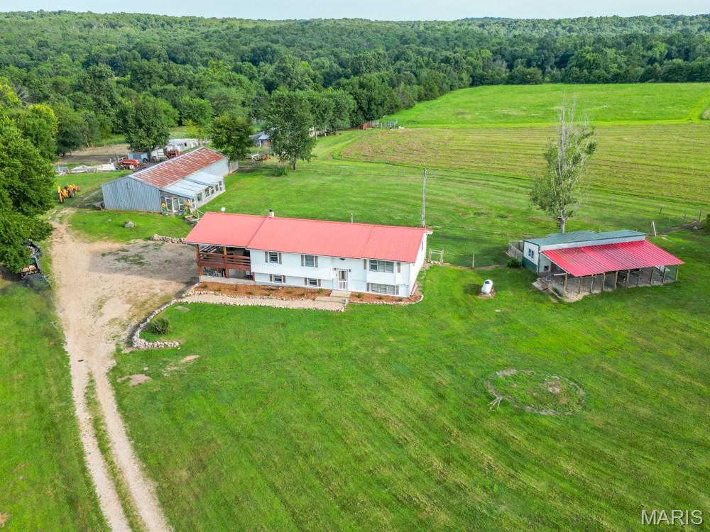 72.63 Acres, 2,722 Sq Ft Home, 3 ponds , 2 concrete floor barns, fenced & cross fenced  with established cross rotational grazing.  Hunting food plots & trails.  Green house, private water well and approximately 30 minutes to Lebanon or St Robert, MO. Where Hunting, Homesteading, and Country Living Come Together

Set along a beautiful drive in the Ozarks, this 72.63 acre hunting and homesteading property offers the rare combination of productive pasture, managed wildlife habitat, abundant water, established infrastructure, and a spacious family home — all within approximately 30 minutes of Lebanon and St. Robert with convenient access to I-44.

The property is thoughtfully divided between hunting and homesteading. Open pasture is fully fenced and cross-fenced with rotational grazing already in place, while the remaining acreage has been intentionally managed for big-game hunting, featuring established trails, maintained food plots, hunting stands, natural travel corridors, and bedding cover. Whitetail deer and wild turkey are regular visitors, whether you're watching them step into a food plot at sunset or exploring the trails by ATV, horseback, or side-by-side. Three ponds and a wet-weather creek add beauty, water resources, and wildlife habitat throughout, and with Mark Twain National Forest and Gasconade River access nearby, even more hunting, fishing, floating, and hiking are just minutes away.

At the heart of the property is a spacious 2,700 square-foot split-level home featuring four bedrooms, three full bathrooms, and an additional non-conforming room (no window) that would make an ideal bonus room or home office. The finished lower level offers valuable living space for family, guests, a home office, or multigenerational living. Outside, the expansive deck creates the perfect place to unwind — gather with family, watch wildlife move across the property, or relax in the hot tub beneath a wide-open country sky.

This is not simply a property with homesteading potential — it is a proven working homestead. The land has successfully supported Mini Jersey cattle, Lowline Aberdeen cattle, mini Nubian goats, KuneKune pigs, and chickens, with fenced and cross-fenced pasture, an established rotational grazing system, and conveniently placed frost-free water hydrants making daily livestock care practical and efficient. Two barns with concrete floors provide space for livestock, hay, feed, equipment, or workshop use, and a greenhouse is already in place for extending the growing season. Six established fruit trees are beginning the foundation of a future orchard, and elderberry bushes add another productive element reflecting the years of care already invested here.

Properties offering this level of privacy, agricultural versatility, recreational value, and established infrastructure are increasingly difficult to find. The fences are in place, the grazing system is established, the trails and food plots are maintained, and the barns, greenhouse, ponds, creek, and water hydrants are ready to serve the next owner. This is more than acreage — it's a hunting property, a working homestead, a private retreat, and an opportunity to create a lasting family legacy in the Missouri Ozarks.

Video: https://youtu.be/SKYKXXcqeaY