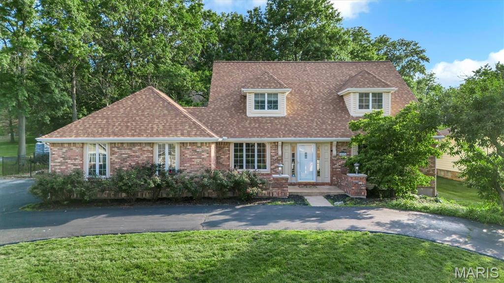 Welcome to refined living in the heart of Chesterfield. This predominantly brick 1.5-story residence offers timeless curb appeal with a circular driveway, beautifully manicured grounds, and an exceptional backyard retreat designed to impress. Step inside to discover a spacious and thoughtfully designed floor plan featuring a private home office, elegant formal dining room, and an inviting living room centered around a warm gas fireplace. The fully renovated kitchen showcases premium cabinetry, matching stainless steel appliances, and a generous eat-in dining space—perfect for both everyday living and entertaining. Just off the kitchen, the main-floor laundry room offers convenient access to both the garage and exterior. A stunning four-season room overlooks the lush backyard, creating the perfect space to relax year-round while enjoying the peaceful outdoor views. The luxurious main-floor primary suite is filled with natural light and offers a true retreat, complete with a beautifully renovated spa-inspired bath featuring a dual vanity, separate shower, and a freestanding soaking tub. Upstairs, the generously sized secondary bedrooms provide comfort and privacy for family or guests. The finished lower level is built for entertaining and offers abundant additional storage space. Outside, enjoy your own private oasis with a large stone patio, expansive fenced backyard, and an incredible waterfall feature flowing into a tranquil pond—surrounded by mature greenery and endless green space. With 4 full bathrooms, a half bath, exceptional updates throughout, and an unbeatable Chesterfield location, this remarkable home combines luxury, comfort, and everyday functionality in one unforgettable setting.