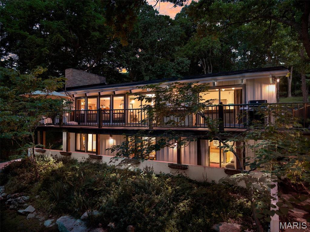 Welcome to “Owls Nest,” a one-of-a-kind Mid-Century Modern retreat nestled in Kirkwood’s Sugar Creek Valley. Located steps from St. Louis’ only Frank Lloyd Wright home on sought-after Architect’s Alley, this stunning 4-bedroom, 4-bath ranch seamlessly blends iconic design with modern updates. Soaring vaulted timber ceilings and an open-concept floor plan create an inviting atmosphere, while expansive windows showcase breathtaking wooded views from nearly every room.

The spacious living room, kitchen, and primary suite all offer direct access to a massive wraparound deck, creating effortless indoor-outdoor living. Enjoy your morning coffee beneath majestic oaks and unwind each evening as custom tree uplighting transforms the property into a private sanctuary. The primary suite serves as a private retreat featuring dual vanities and serene views of the surrounding landscape.

The finished walk-out lower level expands the living space with two additional bedrooms, two full bathrooms, and a spacious family room that is perfect for entertaining guests, hosting game nights, or creating a private guest suite. Step outside to the backyard patio and enjoy the tranquility of this nearly one-acre lot surrounded by mature trees and abundant wildlife.

Recent updates include a new roof and gutters (2026), appliances (2026), electrical panel (2026), HVAC (2018), and sewer lateral (2021). A two-car attached garage, one-car detached garage, and oversized driveway provide exceptional parking and storage options. Located within the highly sought-after Kirkwood School District, this extraordinary property offers the perfect blend of architectural significance, privacy, nature, and modern convenience in one of Kirkwood’s most unique and unforgettable settings.