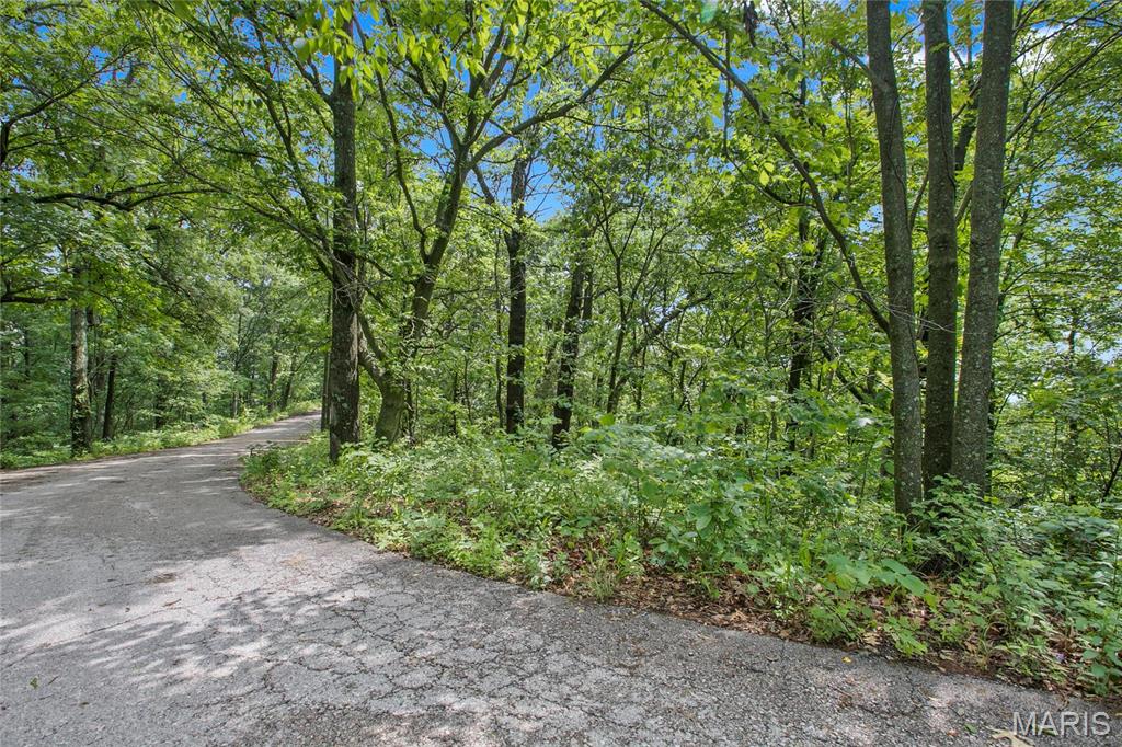 Words can't describe the beauty of this 9+ acres of ground with a view out of this world.  Large corner acres lot with over 1000' of road frontage. If your desire is tall mature trees you've found your home.  This area features large acreage lots with custom homes.   Bring your side by side or golf cart, or take a leisurely walk in the 2+ miles of roads throughout the neighborhood.  Minimum square footage is 2500 on main level for a ranch style home, three car side entry garage is required.  Lot may not be subdivided to keep the number of homes to a minimum on this 300+ acre neighborhood.  Protect your home value and build your dream home today.  Bring your own builder or inquire for pricing for your plan.