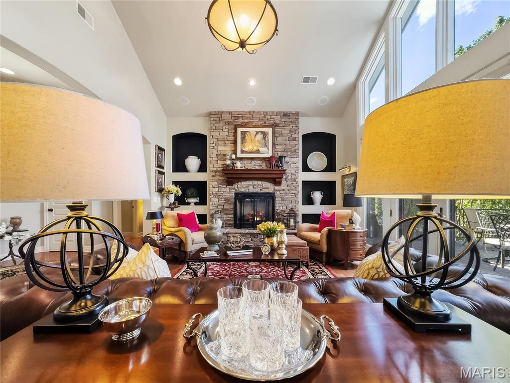 There’s something special about a home that feels private and tucked away, yet puts everything you love about Old Kinderhook right at your fingertips. Set on a beautifully landscaped corner lot just inside the community, this custom-built home offers an incredibly convenient location without the long drive through winding neighborhood roads—and once you arrive, the setting feels surprisingly secluded and park-like. Originally built as one of the builder’s model/office homes, the designer influence is evident throughout nearly 4,000 sq ft of thoughtfully planned living space.

Step inside to soaring ceilings, a striking stone fireplace, and a wall of windows that fills the main living area with natural light. French doors open to the wraparound deck, recently upgraded with composite decking, creating an effortless connection between indoor and outdoor living. The kitchen is equally impressive with abundant custom Mission-style cabinetry, granite countertops, gas cooktop, walk-in pantry, plus a spacious laundry room and dedicated coffee bar.

The main level was designed to live comfortably, offering a generous en suite guest bedroom along with private primary quarters featuring dual vanities, a walk-in closet, and direct access to the deck.

Downstairs, the home shifts effortlessly into entertainment mode. A second living area, large wet bar, and multiple flexible spaces provide room for game tables, fitness equipment, movie nights, or gathering with friends and family. Two oversized bedrooms each feature walk-in closets and share a Jack-and-Jill bath, while two large storage and utility rooms provide the kind of space rarely found in a home like this.

Walk out to a peaceful lower-level sitting area anchored by a recently completed outdoor stone fireplace—a cozy, secluded spot that may quickly become your favorite place to unwind.

Recent improvements include a new roof and gutter guards in 2023, one new HVAC system in 2025, composite decking, extensive exterior stonework, irrigation, and more. An integrated whole-home sound system adds another layer to the entertaining experience, and the included gas-powered Yamaha golf cart makes enjoying the Old Kinderhook lifestyle even easier.

With championship Tom Weiskopf-designed golf, resort amenities, dining, pools, fitness, racquet sports, lake access, and year-round activities all within the gated community, this is more than a beautiful home—it’s an opportunity to live the Old Kinderhook lifestyle every day.