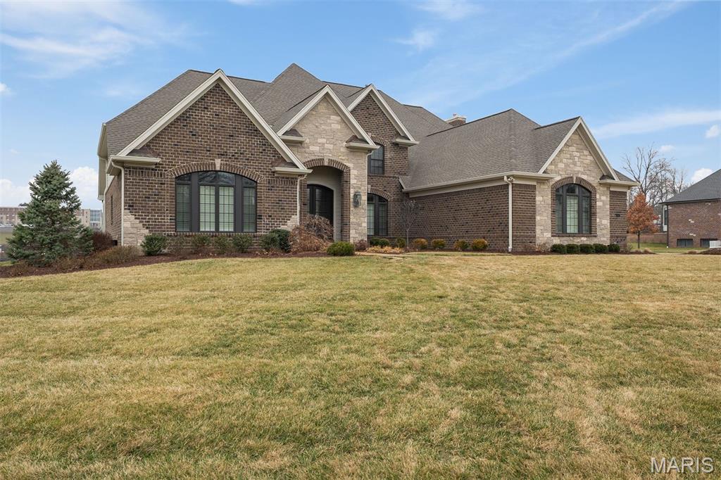 Located in the exclusive gated Stonechase on Conway community in Town and Country, this exceptional brick and stone exterior custom home sits on a private one-acre lot and features a three car side entry garage.  The home offers almost 7000 total square feet of beautifully finished living space which includes five bedrooms, five full baths, and two half baths. Just five years old and highly upgraded, the 1.5-story floor plan features a desirable first-floor primary suite, private office, and a large formal dining room ideal for entertaining. The gourmet kitchen is open to the breakfast area and hearth room with a fireplace and flows into a family room showcasing coffered ceilings, built in bookcases, and a second fireplace. The upper level includes three bedroom en-suites with large walk-in closets and a bonus room, while the fully finished walkout lower level offers a stylish bar, media room, and dedicated fitness room. This move-in-ready luxury home delivers timeless design, comfort, and quality in a premier location.