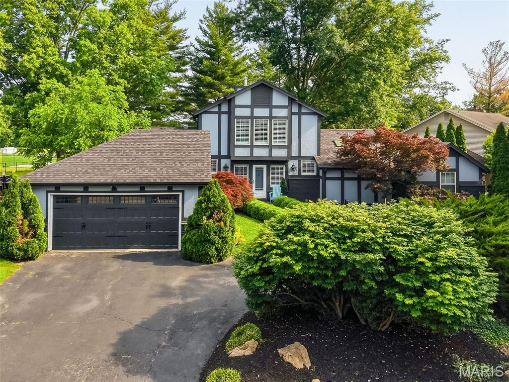 This Tudor-style home blends timeless architecture with sophisticated updates in one of Chesterfield’s most desirable locations. A dramatic two-story foyer welcomes you into a sun-filled interior featuring soaring ceilings, skylights, refinished hardwood flooring, and plantation shutters. The impressive step-down great room is anchored by a striking floor-to-ceiling stone fireplace and flows seamlessly into the elegant breakfast room with a wide bay window and patio access—ideal for entertaining both indoors and out. The beautifully updated kitchen offers rich cabinetry, quartz countertops, stainless steel appliances, and an oversized peninsula with breakfast bar seating, creating a warm and functional gathering space.

The main-level primary suite delivers a true retreat with cathedral ceilings, multiple closets including a custom walk-in system, and an expanded luxury bath featuring a jetted soaking tub, double vanity, and separate shower. A private main-floor office/study with deck access provides the perfect work-from-home setup, quiet reading lounge, or luxurious closet. Upstairs, spacious secondary bedrooms and an additional full bath offer comfortable accommodations for family or guests.

The finished lower level expands the home’s versatility with a large recreation area, wet bar, family room with built-in entertainment center, full bath, and an additional office or sleeping area. Step outside to an exceptional backyard retreat designed for both entertaining and everyday enjoyment. The expanded concrete patio offers multiple gathering areas, highlighted by a large pergola that creates the perfect shaded outdoor living space for dining, relaxing, or hosting guests. Mature trees and lush landscaping provide beautiful natural privacy and a peaceful park-like setting, while the open green space beyond enhances the sense of seclusion and serenity. Situated on a beautifully landscaped corner lot with circular drive, sprinkler system, and easy access to Hwy 40, shopping, dining, and award-winning Parkway schools, this home offers the perfect blend of elegance, comfort, and convenience.