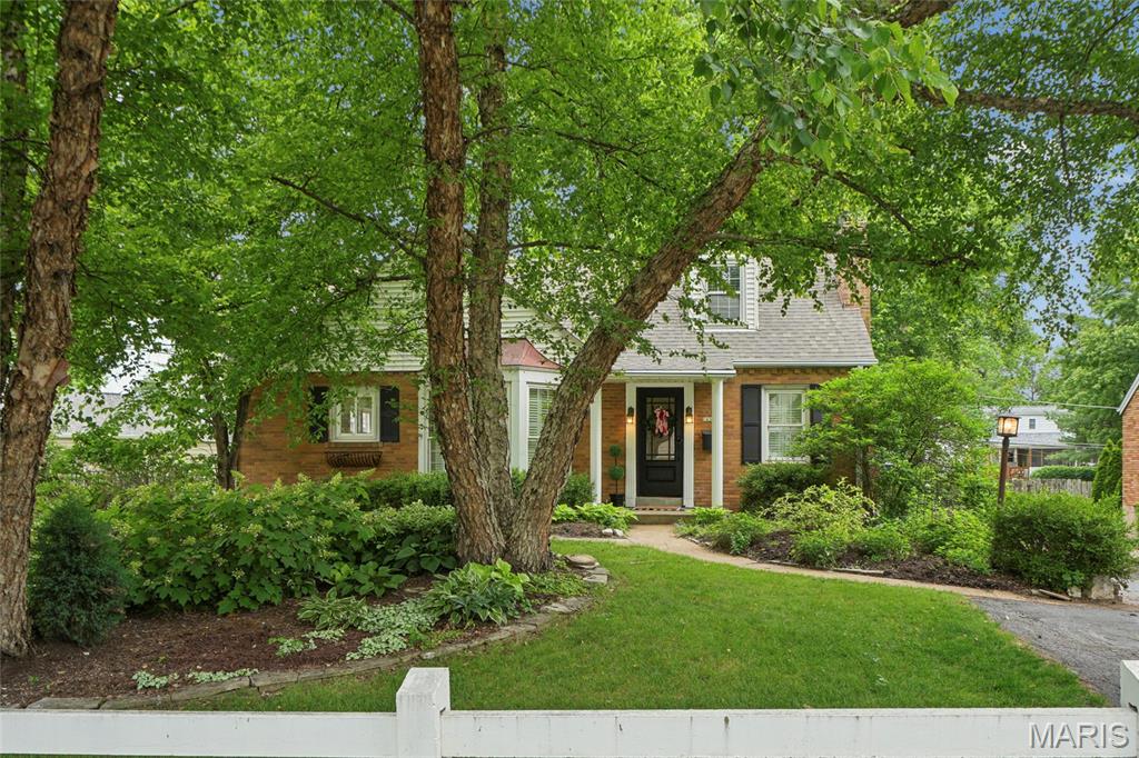 Adorable and full of charm, this 1.5-story, 3 bed/2 bath home in desirable Webster Groves offers over 1,500 sq ft of storybook appeal! From the darling white fencing to the beautifully landscaped grounds, this home radiates curb appeal. Inside, you’ll find a light-filled living room with cottage-style windows, a dining room featuring a stunning bay window and plantation shutters, and a versatile main-floor bedroom with an adjoining bonus room, perfect for a home office, sitting area, or potential walk-in closet.
The kitchen boasts a gas range, center island, and ample cabinetry, opening seamlessly into the cozy family room, ideal for everyday living and entertaining. Upstairs, you’ll find two generously sized bedrooms and a full bath conveniently located between them.
Step outside to a truly magical backyard, your own private sanctuary and gardener’s dream, reminiscent of a secret garden. A beautiful flagstone patio provides the perfect setting for grilling, entertaining, or unwinding after a long day. A 1-car tuck-under garage adds convenience and offers space for a compact vehicle or additional storage.