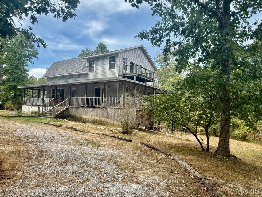 Privacy, acreage, and a great location! This 3-bedroom, 3-full-bath home sits on 20 wooded acres just outside the edge of Houston city limits, offering a secluded country setting while still being only minutes from town. Outdoor enthusiasts will love being close to the Big Piney River, Mark Twain National Forest, and within easy driving distance of the Current River. The home features a spacious wraparound deck, with each bedroom having its own exterior door leading directly to the deck. Inside, you'll find generously sized bedrooms, large walk-in closets, and plenty of living space. The main floor has 2 bedrooms with Jack N Jill bath, and the upstairs has a large Master Suite. The full walk-out basement offers even more possibilities and could easily be finished to add one or two additional bedrooms, a family room, game room, office, or guest space. A two-car garage is conveniently located in the basement. The home is equipped with central electric heat and air, along with an additional outdoor wood furnace for an alternative heat source. With 20 wooded acres, there is plenty of room to enjoy wildlife, hunting, hiking, or simply the peace and privacy of the Ozarks. Whether you're looking for a full-time residence, recreational property, or a private retreat near some of the area's best outdoor destinations, this property offers plenty of potential. Home is being sold as-is.