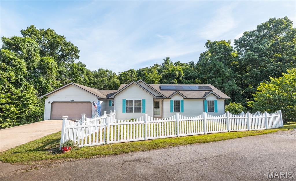 Discover the perfect blend of comfort, style, and efficiency in this beautifully maintained 4-bedroom, 3-bath home located in the highly desirable Rockwood Estates neighborhood of St. Robert. Just minutes from the Main Gate of Fort Leonard Wood, shopping, restaurants, and everyday conveniences, this home offers an ideal location for commuters and anyone looking to enjoy all the area has to offer.

Step inside to a bright, open floor plan featuring soaring vaulted ceilings, gorgeous hardwood flooring throughout the main living areas, and a cozy fireplace that creates a warm, inviting atmosphere. The updated kitchen is designed for both everyday living and entertaining, complete with modern appliances, including a range with built-in air fryer and convection cooking options, ample workspace, and a seamless flow into the dining and living areas.

Designed with both comfort and accessibility in mind, this home offers handicap-friendly features including an Acorn chairlift to the family room, a convenient ramp from the garage, and easy walk-in bathtubs that provide flexibility for a variety of needs. The spacious bedrooms feature comfortable carpeting, creating peaceful retreats at the end of the day. Downstairs, the finished walkout basement expands your living space with a large family room, and endless possibilities for a media room, home office, guest suite, or recreation area.

Additional highlights include solar electricity that helps keep utility costs remarkably low, LeafFilter gutter protection, a water softener, and the added peace of mind of a Choice Home Warranty valid through August 14, 2028.

This move-in-ready home truly combines modern convenience, energy efficiency, and an unbeatable location. Don't miss your opportunity to own in one of St. Robert's most sought-after neighborhoods—schedule your private showing today!