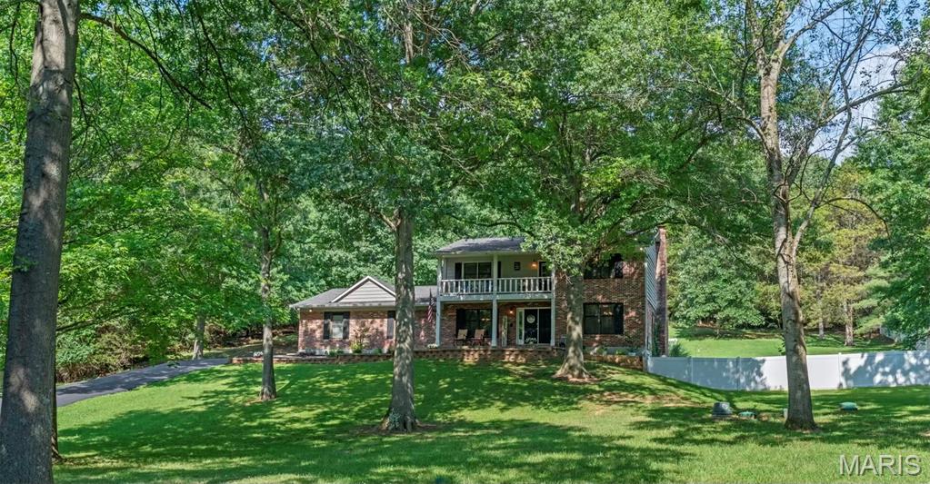 As you make your way down the long private driveway, the noise of the day begins to disappear. Surrounded by 3.1 beautifully maintained acres, this is the kind of property that gives you room to breathe while still offering the quality and finishes you've been searching for. Step inside to an inviting open floor plan where rich hardwood flooring, matching custom staircases, soaring vaulted ceilings, and a wood-burning fireplace create a warm and impressive first impression. Whether you're hosting holiday dinners in the formal dining room, gathering around the breakfast table each morning, or entertaining in the beautifully updated kitchen featuring 42-inch cabinetry with crown molding, granite countertops, stainless steel appliances, and a spacious walk-in pantry, every space has been thoughtfully designed.
Upstairs, the private primary suite offers the perfect retreat, complete with a spacious walk-in closet and a luxurious bathroom featuring heated tile floors, a double vanity with granite countertops, and a custom tiled walk-in shower with dual shower heads. Two additional generously sized bedrooms and an updated full bathroom complete the upper level. Enjoy hours out on the second-story balcony and enjoy peaceful views overlooking your own acreage.
The finished walk-out lower level continues the home's high-end finishes, offering two additional sleeping rooms with closets, a third full bathroom with a double vanity, abundant storage space, and flexible living areas that can easily adapt to your needs. Movie nights will never be the same in the dedicated theater room, and to make the transition even easier, theater equipment can stay with the home.
Outside is where this property truly shines. Professionally landscaped grounds, colorful flower beds, a fire pit, oversized patio, and a newer above-ground pool create the perfect setting for entertaining, relaxing, or simply enjoying the privacy that 3.1 acres provides. Although the spacious laundry room  is currently located in the lower level there is a very large pantry that bumps right behind the main floor powder room if this is something on your wish list.   An irrigation system is already in place and was shut down prior to their ownership (sellers never felt the want to use it), while the attractive brick front and oversized three-car garage add even more curb appeal and functionality. From the moment you arrive until the moment you leave, this home simply feels special. This home comes with a new up to date 3 chamber septic system that was installed in 2024 and a Zoned HVAC system. For additional peace of mind, the seller is also including a one-year choice ultimate home warranty. Open House this Saturday 7/11 from 11am to 1pm.  Don't delay, make this your home today!!