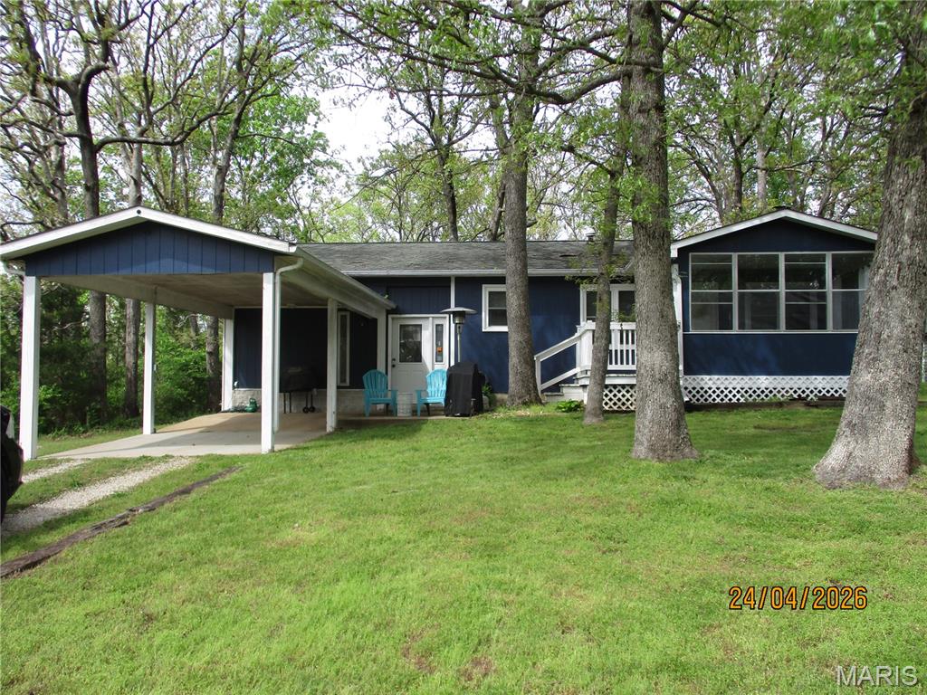 This cute cozy home comes with a good lake view. This home offers  2 bedroom 1 bath a very nice seasoned room and a family room with electric fireplace all comfortable areas to enjoy family and friends. Laminate and carpeting throughout. Wood stove in living room that heats the whole house plus propane heat. Nice kitchen to make your favorite recipes. Master bedroom has good space to arrange your furniture. Good size utility room. Covered carport for parking. Located 1 block from entrance road close to pickle ball courts, marina, country store and beach. Call today to preview this nice place. Seller is relocating and motivated to sell.