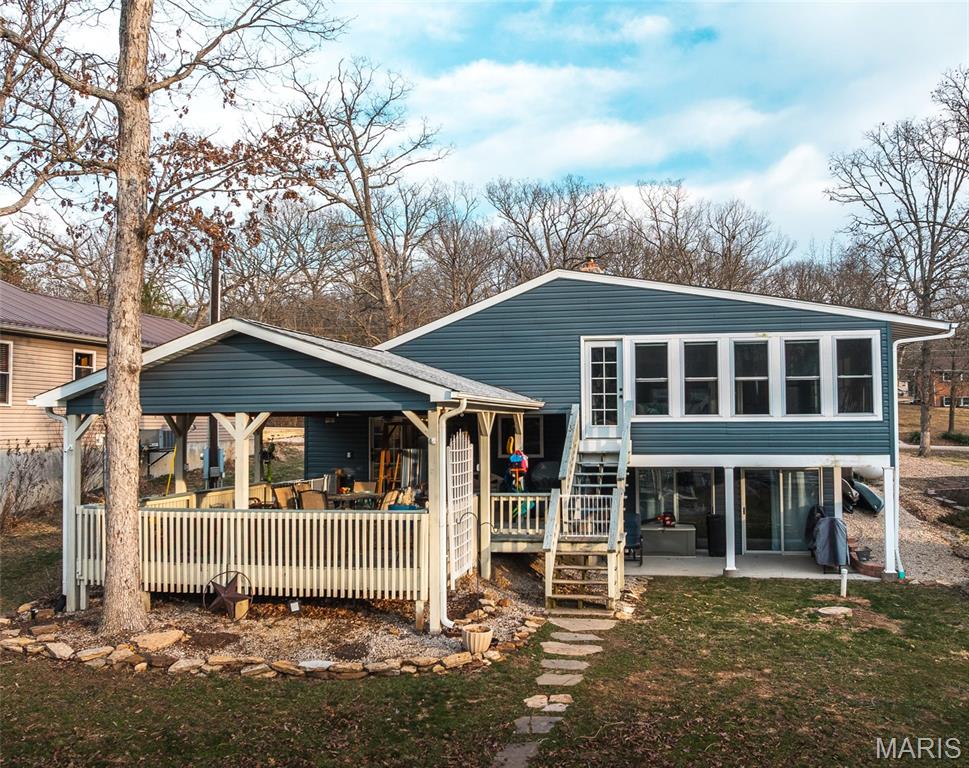 This house makes LAKE LIFE a breeze! Newer dock and lift and a level walk to the water make lake life easy! Situated close to end of cove 7, you can easily swim right off the dock or launch kayaks and canoes. The main floor includes a HUGE eat-in kitchen with all the counter and pantry space you need to feed your crowd. Also on this level is your primary suite with solid surface vanity, bidet, walk in shower and walk in closet. A large laundry/storage room is on this level as well. From the kitchen, the sliding glass doors lead to a large, covered deck overlooking a fire pit and the lake. This lake house is meant to be enjoyed all year round with a cozy wood burning fireplace in the living room. The lower level also features LOTS of storage, a half bath and walks out to the yard. The upper level has a full bath and three generously sized bedrooms. One bedroom has a bonus room with windows all around so guests and family can enjoy the view. Stairs from this room exit to the yard. The 3 car detached garage has space for your vehicles, golf cart and lake toys. Situated near the end of a cove, there is still plenty of water depth, yet it is easy to swim, float or fish right off your own dock.  The house includes many updates and upgrades incuding granite counters, commercial grade flooring and top of the line appliances. A new roof has been installed on the house in June of 2025. Indian Lake is 326 (+/-) acres and allows for boating, fishing, skiing, tubing, swimming, kayaking and more! Community has full service marina, beach/playground area, pickleball/tennis court (recently refurbished), basketball court and volleyball area. The community center hosts a variety of activities including potlucks, bingo, trivia nights, poker runs and other events. It can also be rented for private events.