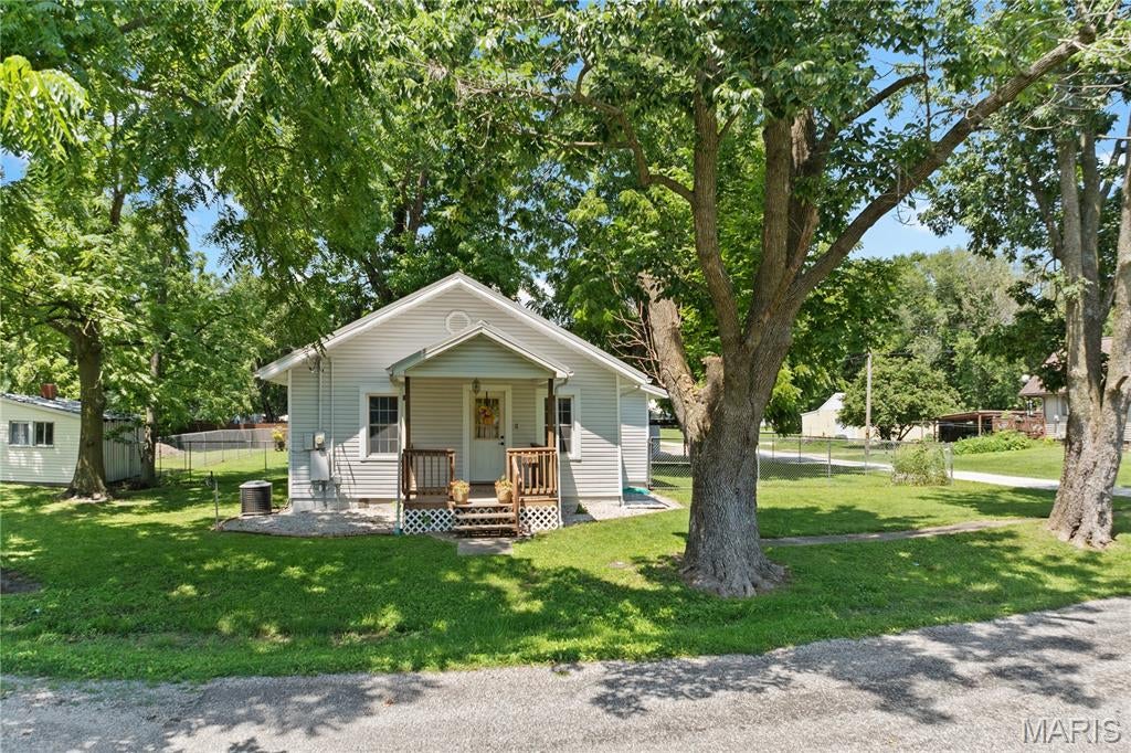 Very well-maintained and full of charm, this 2-bedroom bungalow offers the perfect blend of character, space, and modern updates ? all nestled on two large country-setting lots in Bunker Hill. Inside, you'll find beautiful hardwood flooring, large spacious rooms, and original pocket doors that add timeless character and charm. The convenience of main-floor laundry makes everyday living easy, and the washer, dryer, stove, and refrigerator are all included, making this home truly move-in ready.
Enjoy peace of mind with numerous major updates, including a metal roof just 2 years old, HVAC replaced in April 2021, and a tankless water heater installed in April 2021. Step outside to a fenced backyard, a detached oversized 2-car garage, and a newly added carport providing additional covered parking and convenience. With updates galore, generous outdoor space, and small-town country charm, this lovingly cared-for home is ready for its next owner!