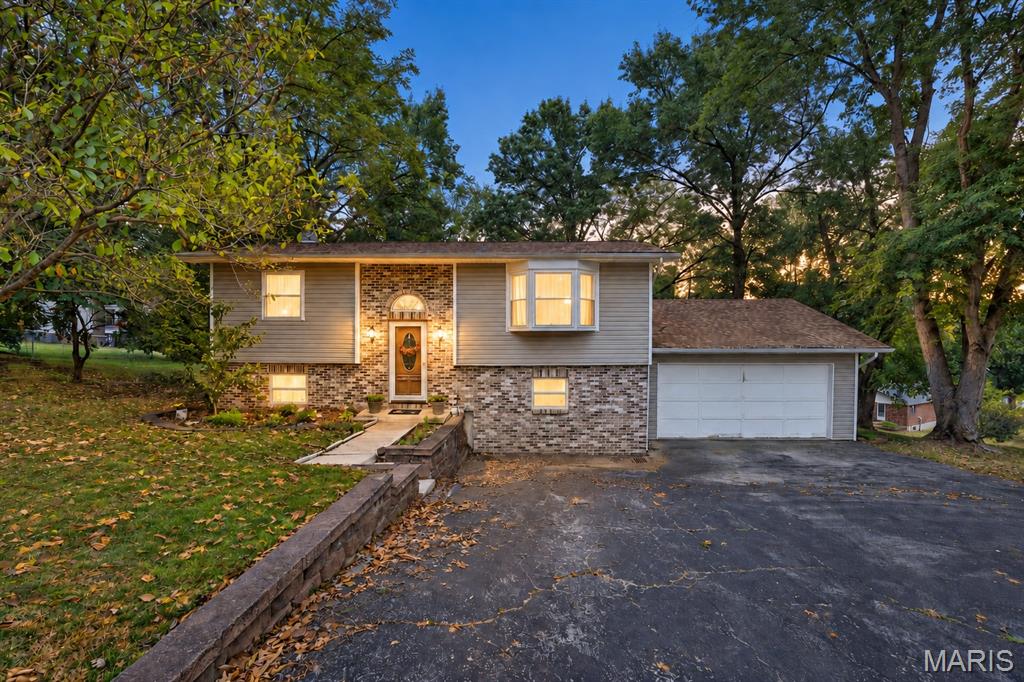 Meticulously maintained home situated on a quiet cul-de-sac where homes rarely become available! From the moment you enter, pride of ownership shines throughout. The true showpiece is the screened-in porch, featuring a vaulted ceiling and maintenance-free decking overlooking a private backyard—perfect for watching the deer and enjoying every season. Gleaming hardwood floors flow throughout the main living areas. The inviting living room features a beautiful bay window, while the thoughtfully designed kitchen offers an efficient layout, charming archways and an adjoining breakfast room. Two main-level bedrooms also feature hardwood flooring and share an updated full bath.
The finished walkout lower level provides additional living space with a spacious family room and cozy fireplace. A generous guest bedroom—currently used as the primary suite—includes a private half bath and doors leading to the covered patio. With multiple indoor and outdoor entertaining spaces, a peaceful setting and an oversized two-car garage, this exceptional home is ready to be enjoyed!