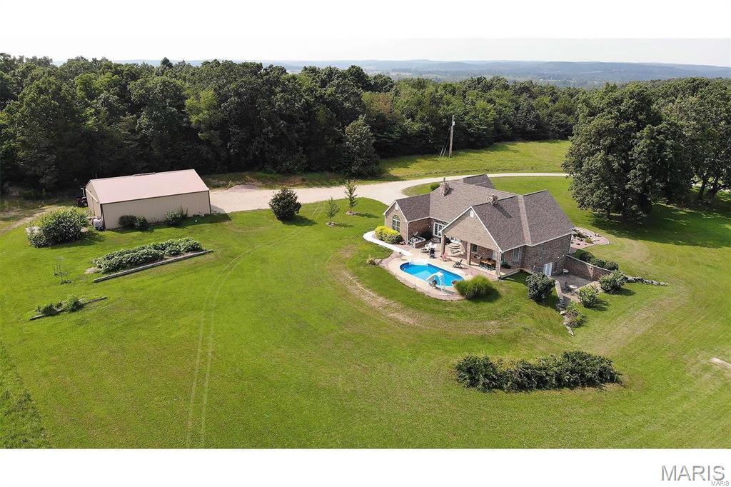 Welcome to this stunning all-brick estate offering over 4,000 square feet of beautifully designed living space, perfectly situated on 43.48 acres m/l of picturesque countryside. This exceptional 3-bedroom, 3-bath home combines timeless elegance with modern comfort, creating a truly one-of-a-kind property. Step inside to a grand entryway featuring impressive columns and graceful archways that set the tone for the home’s refined character. The spacious great room is a showstopper, highlighted by a gorgeous marble fireplace—perfect for gathering and entertaining. The expansive kitchen is equally impressive, boasting granite countertops, abundant cabinetry, and ample workspace to satisfy any home chef. A large formal dining room provides the perfect setting for hosting memorable meals.
The luxurious master suite offers a private retreat with an oversized bathroom featuring double sinks, a relaxing jetted tub, a large tiled walk-in shower, and an incredible dream closet.
Built with quality in mind, this home showcases all USA-made products, including flooring and windows, along with durable 2x6 exterior walls and 8-foot basement walls for added strength and efficiency.
Outdoors, the property is just as remarkable. Enjoy warm days by the beautiful in-ground pool or take in the peaceful views of your private pond. Adding to the charm is a historic cabin dating back to 1875, offering a unique glimpse into the past. Tucked away in the woods, a screened house provides the perfect secluded escape to relax and unwind in nature. Very unique must see property!