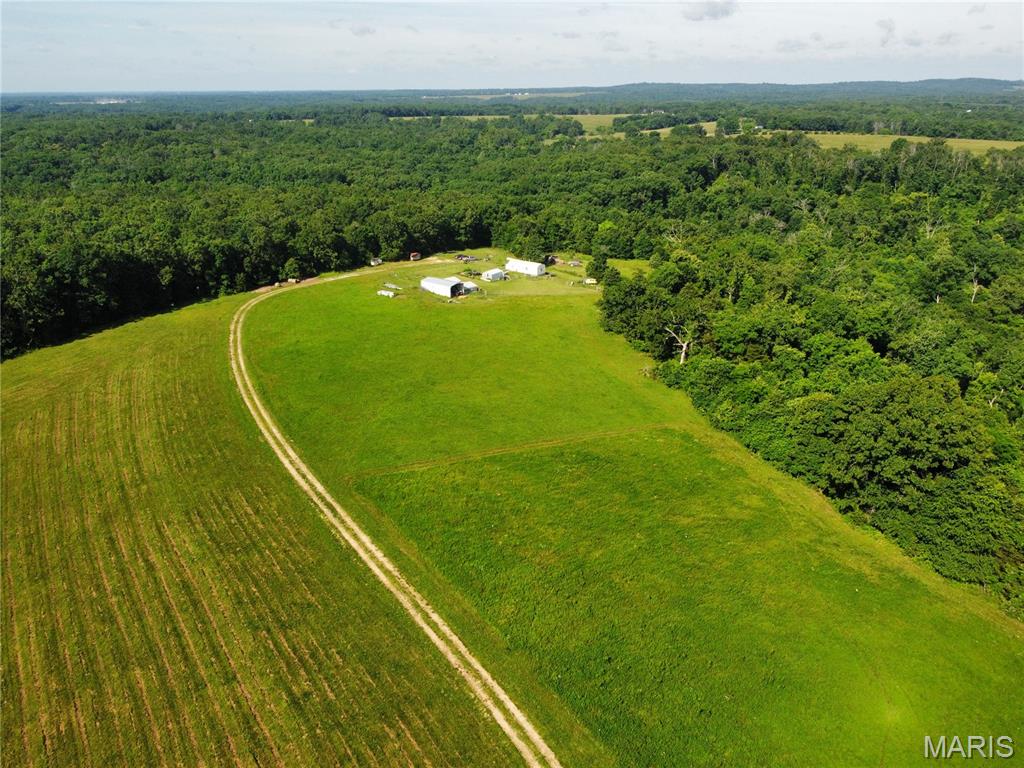 Secluded yet convenient, this 49 +/- acre off-grid homestead is located a short distance from Hwy MM in Dixon. A wooded driveway leads to open land with beautiful hillside views, approximately 20 cleared acres, and a peaceful country setting. At the end of the winding lane, you’ll find a tiny home currently used as a full-time residence, featuring one bath, two storage lofts, a sleeping area, kitchen, dining area, and living space, with setup for a full-size refrigerator, washer, and dryer. The property is equipped with solar panels, a Generac generator, water catchment system, and more. Outdoor features include a pond, barn, shed, fencing, garden area, and space for animals, with current use including sheep, a horse, and dogs. Owner recently ran cows on the property. Whether you are looking for a hunting retreat, horse enthusiasts property, weekend getaway, off-grid lifestyle, potential rental, or a place to build your dream home, this property offers a rare blend of privacy, usability, and convenience. A true must-see to fully appreciate.