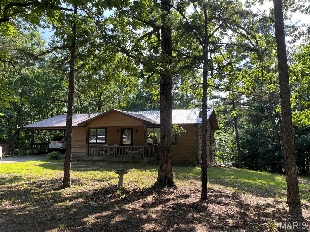 Country home on 2.7 acres m/l with nice, shaded yard. Charming, wood-sided house has a covered front porch, attached 1-car carport, wrap around deck for entertaining, enjoying nature or just getting away to relax.  Back yard has some fencing and 3 chicken houses, portable carport and detached shop/garage. Home has beautiful, real wood floors, spacious open floor plan living room, kitchen with appliances and pantry, separate dining room, bedroom and full bath, all on the main floor. Finished, walk-out basement with so much added living space. Family room, 1-bedroom with room for a second, full bath and laundry room. Don't miss out on all the charm this house has to offer, within just miles of Piedmont.