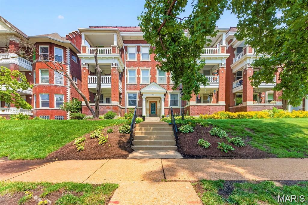 Welcome to 5553 Waterman Blvd., where timeless architecture and classic craftsmanship come together in a prime DeBaliviere Place location, all within easy reach of Forest Park, the BJC Medical Campus, Barnes Hospital, the Delmar Loop, restaurants, coffee shops, groceries, MetroLink, and the WashU shuttle route. This spacious 1,769 sq. ft. condominium offers 2 bedrooms, 1 full bath, and 1 half bath within one of St. Louis' most attractive historic buildings. From the moment you arrive, you'll appreciate the stately brick façade, beautifully landscaped grounds, impressive curb appeal, and secured building entrance. Inside, an elegant stained-glass entry door welcomes you into an impressive foyer featuring ornate plaster ceiling details that beautifully showcase the craftsmanship of a bygone era. You will love the generous living space, gorgeous kitchen featuring granite countertops, stainless steel appliances, abundant cabinetry, and a wall of built-in cabinetry and storage. The adjacent breakfast room provides the perfect spot for casual dining or morning coffee, while the formal dining room offers additional space for entertaining. The spacious living room features built-ins, beautiful hardwood floors, and a walk-out to the covered porch—an inviting place to relax and enjoy the neighborhood. Both bedrooms offer generous space and excellent closet storage. The primary bedroom features a versatile bonus room that could easily serve as a home office, reading room, hobby space, or workout area. An updated full bath and convenient half bath add functionality, while the in-unit laundry with full-size washer and dryer makes everyday living easy.Additional conveniences include secured rear gated parking with a dedicated parking space and a location that puts so much of St. Louis at your fingertips. With its spacious floor plan, historic architectural details, beautiful updates, covered porch, dedicated parking, and highly walkable central location, 5553 Waterman Blvd. offers a wonderful opportunity to enjoy all that DeBaliviere Place and the surrounding area have to offer.