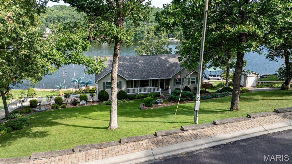 Get ready to cast your line into the good life at 1552 Woodson DR, OWENSVILLE MO 65066! This 4 bedroom, 2.5 bathroom residence is in great condition, practically winking at you to come and enjoy its attractive charm. Whether you're looking for a weekend home on PVL or looking your family's new home, this is perfect!! Welcome to Peaceful Valley Lake, this 175 acre lake has many amenities for your family to enjoy. Some of these amenities are a pool, clubhouse, beach, playground, and much more. This home itself is breathtaking! Pull in the driveway and you already know this home is well maintained and the park like yard is just amazing, with the most breathtaking views! Stroll in the lower-level door and enjoy all this area has to offer like a wet bar, mini fridge, a handmade beautiful real wood bar, propane fireplace, 1/2 bath, views to die for, storage area, 2 car garage and so much more!! Travel up the stairway to your main level, this stairway is also made from real wood to give a unique look.  Immediately you notice the large kitchen with plenty of storage, and an island conveniently placed, and plenty of space in the dining area to rearrange to your family's needs. The family room hosts one of the best views in this home!! The family room provides a welcoming atmosphere, centered around a cozy fireplace, perfect for gathering and relaxation designed with vaulted wood ceilings, expansive windows that let in an abondance of natural light, and much more! The sunroom is another favorite! You can gain access to the sunroom from 3 ways, the master bedroom, family room, or the outside which makes it an even cooler space for you to unwind! With four bedrooms, there's plenty of space for everyone to claim their own little slice of paradise.  All 4 bedrooms have carpet flooring, closets, and large windows. The master bedroom has a full bathroom with walk in shower, his and hers closets, and access to the sunroom! This home has a newer roof, put on in 2025, a brand-new front door (Anderson), all Anderson windows and much more! Step outside to enjoy the expansive outdoor dining area, ideal for al fresco meals and entertaining guests, all while taking in the tranquil waterfront views. A private dock extends your living space directly onto the water, inviting you to enjoy boating, fishing, or simply the peaceful ambiance. When outside please take a minute to enjoy the miraculous views of the lake, a nice 1 slip boat dock, a pristine yard that is nicely landscaped, lots and lots of room for hosting, a dry bar, a patio, TV for those parties, an outside closet/ storage room, a shed, and so much more!! The 2-car garage has a ton of built in storage, and the storage room has access to the downstairs bar area and the garage. So, if you're ready to dive into a life of leisure and laughter, this is the place where your next adventure begins!