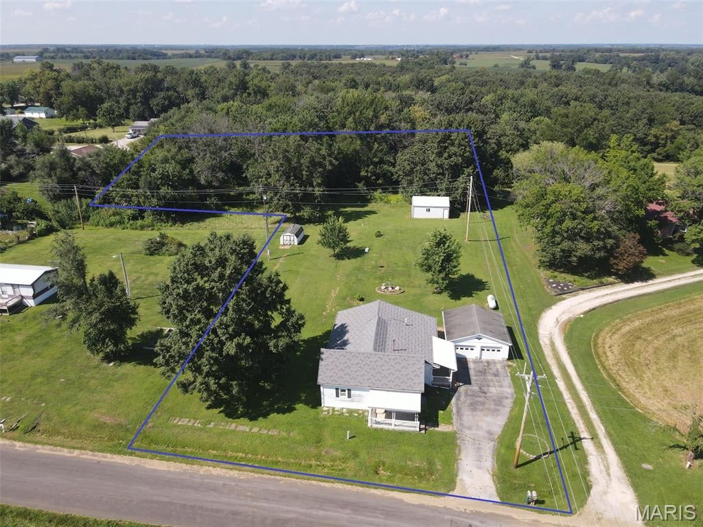 Small town living at its best!  Sitting on the very edge of town on over an acre, this homestead has been in the family for over 70 years, and might not be available again anytime soon.  The 1,664 sq ft home offers 3 bedrooms, a full bath, oversized family room, spacious kitchen/dining area and a sunny living room overlooking the covered front porch.  Step outside the kitchen onto the covered side deck and walk right to the oversized 2-car garage.  The back yard spans clear back into the woods, and also includes a nice 20x24 heated workshop (formerly a wood shop) with overhead door.  You'll love this quiet, secluded location!  Inside the home offers an easy layout, updated kitchen, and all appliances convey.  There also appears to be hardwood floors under most of the carpet.  The metal roof is less than 5 years old, and the zoned heating & cooling systems has two furnaces that were both replaced last year, as well as one of the a/c units.  This is a convenient location just off Hwy 6, and only 20 min to Quincy, IL and 10 min to Lewis County C-1 Schools.  Utility providers here include REC Electric, Lewis County Water, Mark Twain Internet, septic tank & lagoon, an owned propane tank, and several trash options available.  Don't wait around and let this one get away!
