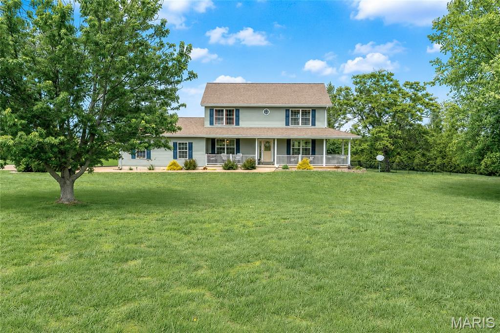Spacious 5 bed, 3.5 bath home offering approximately 3,200 finished sq ft on 3 acres. The main level features a spacious kitchen with stainless appliances and center island  that flows into inviting living spaces, including a welcoming living room, a cozy family room perfect for gathering, and a dining area ideal for hosting family meals or entertaining guests, along with a convenient half bath. Upstairs you’ll find the primary suite, three additional bedrooms, and a full bath. The walk-out basement provides excellent additional living space—perfect for a second family room, playroom, or recreation area—plus an extra bedroom and full bath. Additional highlights include hardwood floors throughout  and new siding in 2023. Enjoy the outdoors from the covered front porch or the expansive back deck overlooking the fenced in backyard. Located just a short drive to town, this move-in ready home offers space, comfort, and convenience for the whole family.