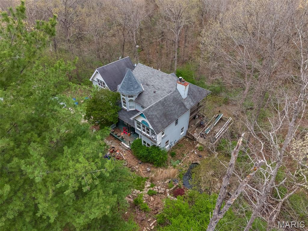 Victorian Charm Awaits On 3.4 Acres In Wildwood! Set on a prestigious drive lined with equestrian estates and lush woods, This classic Victorian offers a rare combination of privacy, acreage, and untapped potential. The peaceful private setting is matched by timeless architectural character and the beautiful exterior views, hints at what this home could become. Inside 4 bedrooms, 4 baths provide ample space, complimented by 2 cozy fireplaces, a finished walk-out lower level, A separate 22' X22' studio/home has been built with a full basement that is awaiting finishing touches to make it yours. This is a true blank canvas--a chance to bring your vision and your contractor to a home ready for a complete transformation into 2026 and beyond! Located in the highly coveted Rockwood School District. This wildwood treasure combines prestige, acreage, and one of the most beautiful lots you've ever seen! 25 Red Bud Trees can be viewed from back deck. Sold AS-IS, bring your imagination-This one is ready to be reborn.