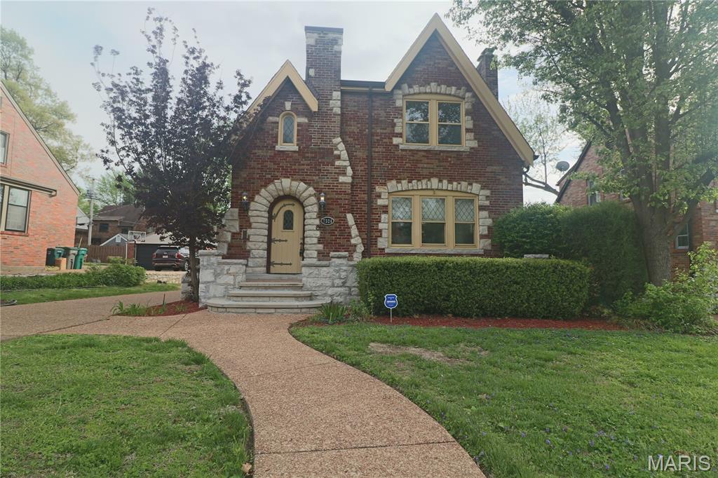 NATIONAL REGISTER OF HISTORIC PLACES....Historic home in the St. Louis suburb of Pasadena Hills. This Classic English Tudor Revival Features elaborately detailed Multi-colored brick with infused ashlar limestone rock. The castle-like entrance features a large tile open porch and limestone arch with wood plank door and vintage hardware. The roof line is steeply pitched with intersecting cross gables that merge into a large chimney with a shed roof behind it. There are some arched windows, some with stained glass, and arched interior doorways. Enter the foyer to this inviting home.  Feel the allure that draws you into the formal area, beaming floors lead you to the formal dining area. Complete with Large Picturesque window in Living Rm and Dining Area. Continue on into the sitting area which provides for extra comfort  on the main level. Kitchen features light ash cabinetry ,tiled countertops, ceiling fan, natural lighting,...Kitchen leads to nice deck and  patio.  Two Car Detached Garage.   Upper level graciously offers 3 roomy bedrooms.  All with ceiling fans and ample closets.  Second bedroom leads to second level deck., with beautiful overlook of the groomed back yard. Master bedroom is expansive , featuring walk-n closets, en suite washer/dryer hook up. Updated Full master bath with massive shower !  Basement is freshly painted and clean.  New hardware on doors.  Tree lined streets create a walking community to nearby fountain and pond.  Minutes  drive away from University of Missouri!. Tour this lovely home by video :    https://youtu.be/DTUOXG2_9TI