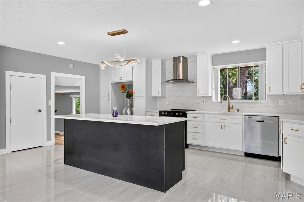 REMODELED home in the heart of Ballwin. If you think you have seen this home before.......you have not! You will fall in love with your new home from the moment you pull up and see the unique frame and curb appeal.  As you enter the front door you will see her in all her glory!  On the left is your TWO-STORY living room where all the natural light from those grand windows shines in through the exposed beams that truly frame this room wonderfully. Imagine snuggling up to a wood-burning fireplace come this winter! This room can be used for whatever your heart desires. (Den, Office, Library, Music room, Playroom). The open-concept kitchen and dining space is the heart of this beautiful home. Brand-new cabinetry, quartz countertops, and a huge island/breakfast bar with seating. Hours of entertaining or family dinners await this space. Off the kitchen is a two-car garage for convenience. Onward to the upper level where you will find the show-stopping primary suite. Vaulted ceilings with exposed beams give this a 'retreat' feel. Plenty of closet space and a beautifully updated full bath. Travel to the secondary bedroom level where you will find the additional bedrooms. Generously sized and awaiting their use! A fully renovated full bath in the hall serves guests and homeowners beautifully. The unfinished lowest level with 9-foot ceilings is ready for you to finish for more livable square footage. Dual HVAC systems, and a laundry area finishes off this clean and dry LL. Out back you’ll find a patio and level yard that overlooks peaceful trees that give you privacy and serenity for unwinding. This home is within the Parkway West School District and just minutes from shopping, dining, and access to Highway 141!  Roof is approximately 1-year old. Don't wait!