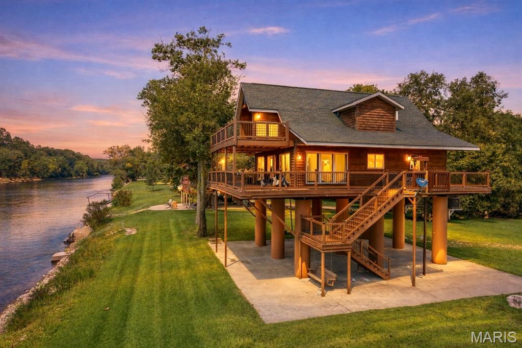 CURRENT RIVER CABIN - RIVERFRONT, 2 ACRES, MINUTES FROM DONIPHAN

Experience the beauty of the Current River from this beautifully maintained riverfront cabin situated on approximately 2 acres just minutes from Doniphan, Missouri. Offering the perfect balance of privacy and convenience, this property provides direct river access while still being a short drive to shopping, dining, and everyday amenities.

A standout feature of this home is the newly installed exterior lift, offering effortless access to the main living level--making it easy to transport groceries, luggage, and gear with minimal effort. It's a rare and highly functional upgrade that sets this property apart from typical river cabins.

River access is exceptional, featuring both a private gravel boat ramp for easy launching and a concrete boat dock with steps that provides a stable, finished entry point to the water--ideal for swimming, fishing, or simply enjoying the Current River up close.

Outdoor living is equally impressive with a spacious wrap-around deck showcasing sweeping river views--perfect for relaxing, entertaining, or taking in the sunset. Below the home, a large covered concrete patio offers a shaded gathering space after a day on the water.

Inside, the open-concept main level features a bright great room and a well-appointed kitchen with quartz countertops. The main floor includes one bedroom and a full bath, while the upper level offers two additional bedrooms and another full bath. One upstairs bedroom features a private expanded balcony overlooking the river.

The grounds are improved with zoysia sod and an in-ground sprinkler system to help maintain the lush lawn. A lower-level toilet adds extra convenience for outdoor and river activities.

Offered fully furnished with appliances included, this turn-key Current River retreat is ready to enjoy from day one. Ideal as a river getaway, vacation home, or investment opportunity.