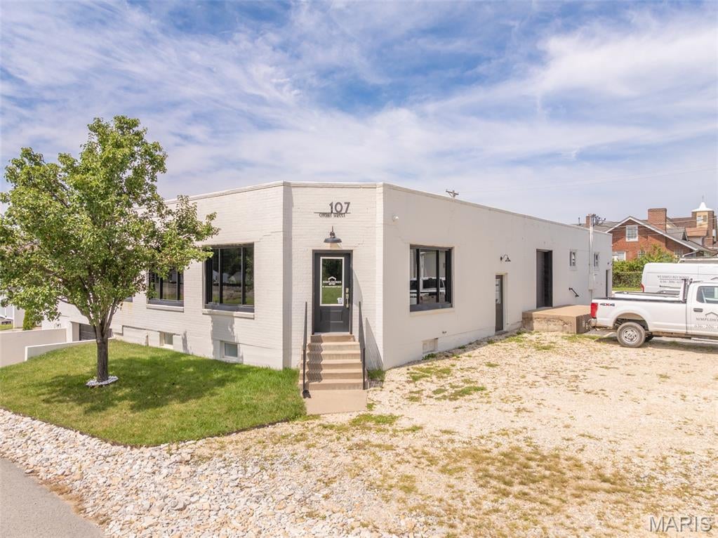 Available for lease is an approximately 10,050 SF office, flex, and warehouse building, with an alt address at 107 Cherry Street in Wright City, Missouri (same location). The building is split between a main level of roughly 5,250 SF and a lower level of 4,800 SF. The main level  has recently renovated finished office space and flex/warehouse space. The lower level offers approximately 2,400 SF of finished space and approximately 2,400 SF of unfinished garage/storage space. A small portion of the main level sits without basement beneath it, accounting for the small difference between the two levels.

The finished office suite features five private offices, an entry foyer, reception area, conference room, kitchen, and bathroom. The front entrance is not handicap accessible, but a rear ramp provides accessible entry.  The adjoining flex/warehouse space offers central heating and cooling, approximately 9.5’ average ceiling height, a loading dock (approx. 2’2” high) with a dock overhead door approximately 6’ wide x 7’ tall, a rear covered ramp, and a sprinkler system throughout the main level — ideal for light industrial, distribution, or service-based users.

The finished lower level includes three large rooms suitable for a variety of permitted commercial uses, along with a full kitchenette (refrigerator, stove/oven, sink) and two full bathrooms with showers. The unfinished lower level offers additional garage/storage space with large garage-door access and two electric heaters. The building’s electrical service includes four separate 200-amp panels.
A versatile opportunity for a tenant seeking a combined office, flex, and warehouse footprint within a single building. With recently renovated main-level office space, functional warehouse space featuring loading dock access and sprinkler coverage, a finished lower level offering a kitchenette and full bathrooms, and substantial additional storage and garage capacity, the property is well positioned to accommodate a broad range of commercial users. Its location less than half a mile from the I-70 interchange adds further appeal for tenants with regional access or distribution needs. Asking $12 a SF + NNN, Approximately $10,050 monthly base rent, NNN expenses to be quoted separately. All square footage and dimensions are approximate and provided for marketing purposes only. Tenant should independently verify measurements if material to its use.