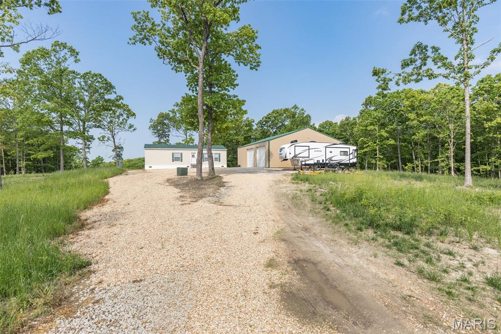 This rural retreat in the heart of beautiful Missouri countryside is ready to be your weekend getaway or forever home. 122 acres off Goose Creek Road in Washington County easily accessible by a well-maintained county road. It features a 6-year-old manufactured 3 bedroom 1 bath home with new roof and a newer 40x60 shop with electric and concrete shop for vehicles and storage. The land boasts of rolling mature timber with nice ridge tops and oak flats. Accessing the property is convenient via an established wide trail system that runs along the perimeter of the property. There are 2 nice ridge top food plots in place and also 2 wildlife watering holes. Deer, turkey, and other wildlife are plentiful, making this property ideal for hunting or nature enthusiasts. If having your own private acreage isn't enough, you are a short distance from many conservation areas and thousands of acres of National Forest for additional recreational opportunities This is truly a turnkey property just waiting for you to enjoy! Schedule a showing now to see first hand the potential this piece of Missouri wilderness has for you.