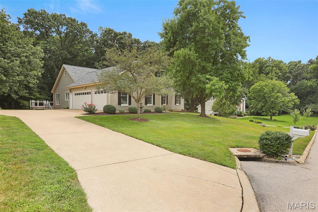 Pride of Ownership in this Spacious RANCH in Popular Lake St Louis! Great Street Appeal! Low Maintenance Siding! Nice Landscaping.  3 CAR Oversize GARAGE and  Extra Driveway Parking! Beautiful .87 Acre Lot-BACKS TO TREES!!!!  A Feel of Privacy when Relaxing on the Deck! All Rooms are Generously Sized. Beautiful Wood Flooring Flows from the Entry Foyer into the Dining Room, the Large Vaulted Great Room with Fireplace AND into the Huge Kitchen with a Bright Breakfast Room.  Kitchen Features:  Stainless Appliances, Granite Counters, Extra Long Breakfast Bar/Center Island, Planning Desk, Pantry and Bright Breakfast Room.  Breakfast Room Opens to Extra Large Deck with Steps (for Pets or Little Ones) Overlooking Tranquil Backyard-Great for Outdoor Entertaining!  MAIN LEVEL LAUNDRY ROOM/MUD ROOM with Adjoining Half Bath and enters directly from the 3 Car Garage.  4 Bedrooms on Main Level including the Primary Bedroom with Walk-in Closet and Private Remodeled Luxury Bath featuring Double Sink Vanity, Soaking Tub and Separate Walk-in Shower. 3 Full Baths and 1 Half Bath on Main Level with Updates. OPEN and WIDE STAIRCASE LEADS TO  SO MUCH EXTRA LIVING SPACE IN LOWER LEVEL-YOU WILL BE AMAZED!   LOWER LEVEL: 2 More Bedrooms with Full Windows, 4th Full Bath, 2 Recreation Rooms including 1 Recreation/Family Room with Fireplace and Wet Bar and Wood Flooring AND THE OTHER with So Much Space for Pool Table, Play or Workout.  In Addition, there is an Office Area with Built-ins that is Great for Work at Home and a Workshop Area for the Handy Person  plus Plenty  of Storage Space. Rooms in Lower Level could also be Perfect for Mother in Law Quarters or Out of Town Guest Quarters. Walkout from Lower Level to the Patio to Relax and Enjoy the Tranquil Backyard! Beautiful Wood Floors, Newer Carpet, Six Panel Doors, Ceiling Fans, & More!!!  Great Location....Minutes to Lake Forest Country Club/Golf.... Lake St Louis Amenities Available.  Short Distance to 364, Shopping &  Restaurants. See To Appreciate!