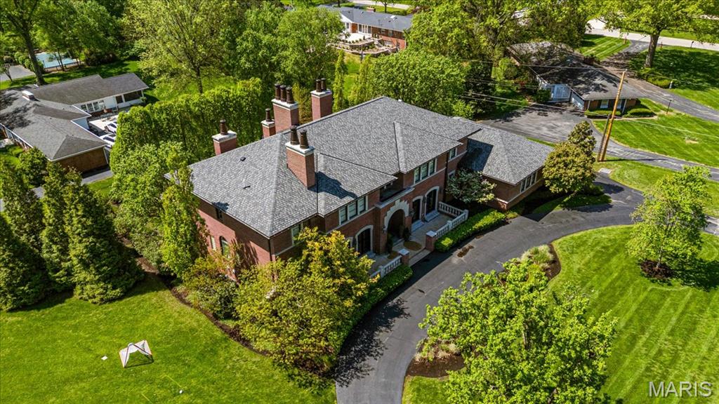 Discover this recently updated Ladue home, designed for luxurious living and entertaining. Step inside the inviting entry foyer, flanked by a wood-paneled den with a new custom stone fireplace and formal dining room boasting elegant French doors. The formal living room features a stunning wall of windows and doors that open to a back deck with adjacent wetbar making outdoor entertaining and dining in front of the outdoor fireplace a breeze. The gorgeous kitchen is the heart of the home, with hearth and breakfast rooms surrounded by windows that fill the space with natural light. The main floor primary suite offers a cozy fireplace and spacious his and her closets. Upstairs, four large bedroom suites provide comfort and privacy, including one with its own fireplace. The lower level impresses with a glass-enclosed wine cellar and tasting area, walk-behind wetbar, gym, golf simulator, theater, and a rec room opening to a covered patio overlooking the sparkling pool. A light-filled guest bedroom and convenient laundry rooms on both the main and second floors complete this exceptional property