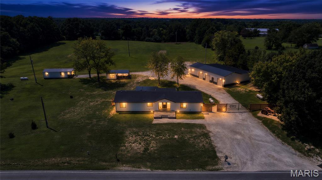 Renovated from top to bottom, this exceptional 6-acre property in Millersburg offers the perfect blend of modern comfort, peaceful country living, and incredible versatility. The 1,796 sqft home features 3 bedrooms (one non-conforming for closet) and 2 full baths, including a spacious primary suite with a walk-in closet and a luxurious ensuite showcasing a standalone shower and two-person soaking tub. Large living room windows and French doors in the dining room frame views of the beautifully manicured acreage, bringing the outdoors in. The updated kitchen includes newer appliances, and yes--the refrigerator stays! The laundry room is thoughtfully designed with front-load washer and dryer, surrounded by custom built-in cabinetry. Step outside to a large covered stamped concrete patio, perfect for relaxing or entertaining. Guests or extended family will appreciate the 450 sq. ft. guest house complete with a kitchenette, living area, bedroom, and full bath. The property also features newer windows, a newer roof, and durable metal siding for added peace of mind. Hobby farmers will love the 12x16 chicken house, while mechanics, entrepreneurs, and RV owners will be amazed by the 24x60+ shop featuring a heated work area with a lift, crane, air-conditioned workspace, additional climate-controlled storage room, attic storage with built-in shelving, and an oversized RV-height carport. Conveniently located in Millersburg, just minutes from Columbia, Jefferson City, and Fulton, this one-of-a-kind property truly has it all!