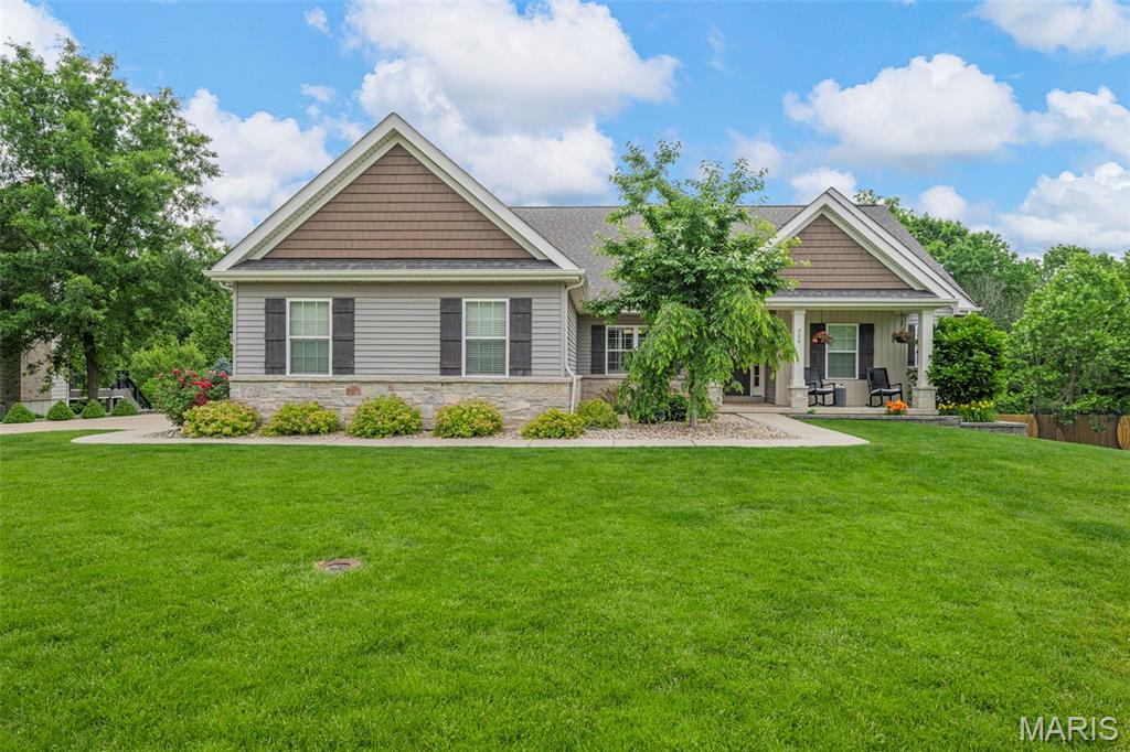 Welcome to this stunning custom ranch home offering luxury finishes, thoughtful design, and resort-style outdoor living on a beautifully landscaped lot. From the moment you arrive, the impressive curb appeal, manicured grounds, and inviting covered front porch set the tone for the quality found throughout.

Inside, soaring vaulted ceilings, rich hardwood flooring, and expansive open living spaces create a warm yet sophisticated atmosphere. The kitchen features custom cabinetry, granite countertops, stainless steel appliances, and oversized island seating with seamless flow into the dining and living areas. A conveniently located powder room adds both functionality and comfort for guests.

The spacious primary suite offers a relaxing retreat with a primary bath featuring dual vanities, walk-in shower, and separate tub. Two additional bedrooms connected by a Jack-and-Jill bathroom complete the main level.

The finished lower level adds incredible versatility with two additional bedrooms along with a large family/media room and a stunning custom wet bar featuring quartz countertops, built-in cabinetry, refrigerator, ice machine, microwave, and sleek modern finishes — ideal for hosting guests or relaxing at home.

Step outside to your private backyard oasis featuring a gorgeous in-ground pool with tanning ledge, expansive deck, covered stamped-concrete patio, multiple entertaining spaces, and peaceful wooded surroundings. Every detail of the outdoor space has been thoughtfully designed for relaxation and entertaining.

Additional highlights include an oversized 3-car garage, professional landscaping, updated finishes throughout, and meticulous pride of ownership. This one-of-a-kind home perfectly combines upscale living with everyday comfort.