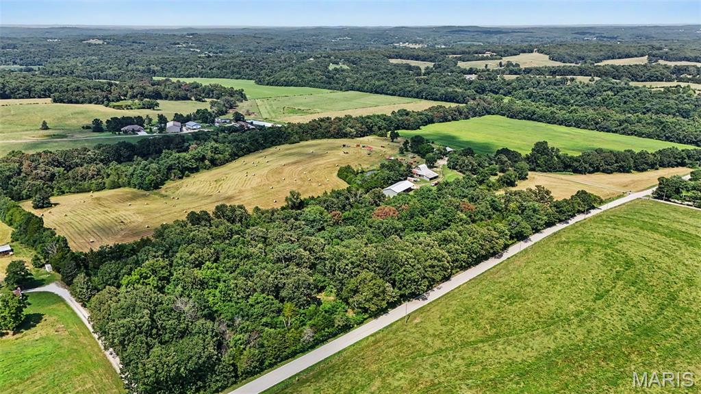 If you've been searching for a real farm with a cozy farmhouse and plenty of room to work the land, this is it. Situated on approximately 78 acres, this property offers the privacy, functionality, and country charm that are becoming increasingly difficult to find.

The 2,229 square foot home features 4 bedrooms, 2.5 bathrooms, beautiful hardwood floors, a charming country kitchen, expansive living room windows overlooking the property, and a walkout basement with a cozy wood burning stove. A covered wrap around porch provides the perfect place to enjoy the peaceful surroundings and scenic countryside.

Currently used for hay production and crops, the land is well suited for cattle, horses, hobby farming, or those looking to embrace the homesteading lifestyle. Some perimeter fencing and fencing around the front pasture are already established. Enjoy a stocked pond with largemouth bass and bluegill, creek access, open pasture, and productive acreage that offers both recreation and agricultural opportunities.

**Be sure to checkout the video and the LIVE floorplan links!**

The property's outbuildings provide the infrastructure needed for country living, including a historic barn full of country charm and potential, machine storage, workshop space, covered equipment storage, and dedicated hay storage.

Whether you're looking to continue its agricultural use, start a homestead, or simply enjoy the peace and beauty of country living, this property offers the space, functionality, and character to make it your own.
**Be sure to checkout the video and interactive floorplan**