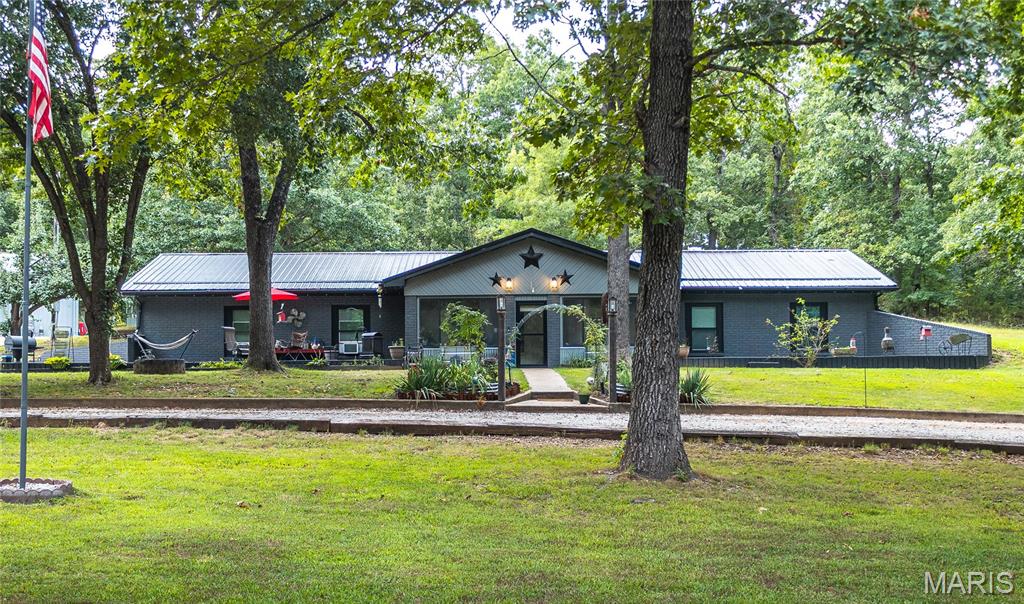 Welcome to 15801 Hargrove Rd in St. Robert! This 4 bedroom, 2 bath home sits on 4 beautiful acres surrounded by mature trees, offering plenty of privacy and room to enjoy the outdoors. Inside, you’ll find a comfortable layout with spacious bedrooms, a beautiful kitchen with custom lighting, butcher block counter tops, and plenty of storage. This home has a bright sunroom that provides the perfect spot to relax and take in the peaceful surroundings. 
Step outside to enjoy not one, but two decks perfect for entertaining, grilling, or simply enjoying the quiet setting. The property also features an impressive 30x40 shop equipped with electricity and its own full bathroom, providing plenty of space for a workshop, hobbies, projects, or additional storage. 
This property offers the serenity of country living without sacrificing convenience. Enjoy being out of city limits with easy access to I-44 and Fort Leonard Wood making this property the perfect place to call home!
