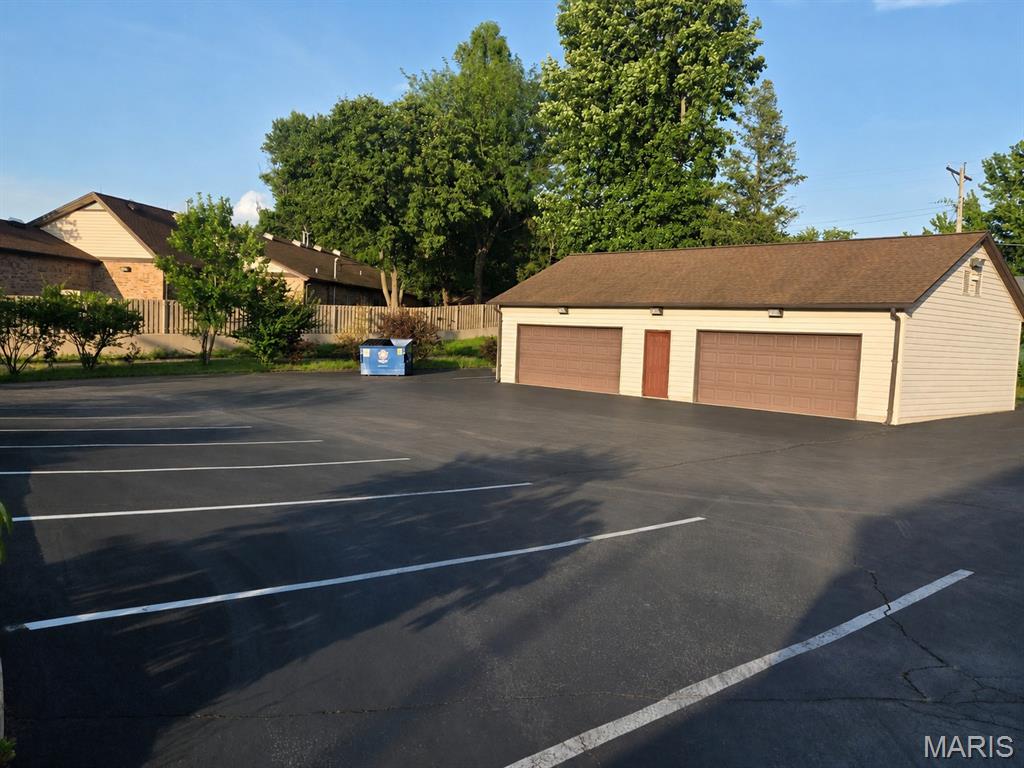 Climate Controlled Garage/Warehouse with Fleet Parking and a Furnished Office in an adjacent building.  1,200 sq ft heated/cooled detached garage with large paved fleet parking.   Garage is 48’ x 26’ with two 16' x 7' overhead doors, 9'6" ceilings, three-ton AC, 200 Amp Electrical Panel, and enclosed capacity for five+ vehicles, ideal for work trucks, tools, equipment, or climate-sensitive materials.  The parking lot offers 29 striped spaces plus additional open areas suitable for trailers, RVs, equipment, and larger commercial vehicles, supported by extensive exterior lighting.  The lease package includes the garage and designated parking/staging area on an NNN basis, plus one furnished 10' x 10' office with shared restroom access in an adjacent building at no additional NNN charge.  Larger office options may be available by negotiation.  Prime Bridgeton location near STL Airport and major corridors.  Well suited for contractors, fleet operators, delivery services, and businesses needing enclosed storage plus substantial paved parking.