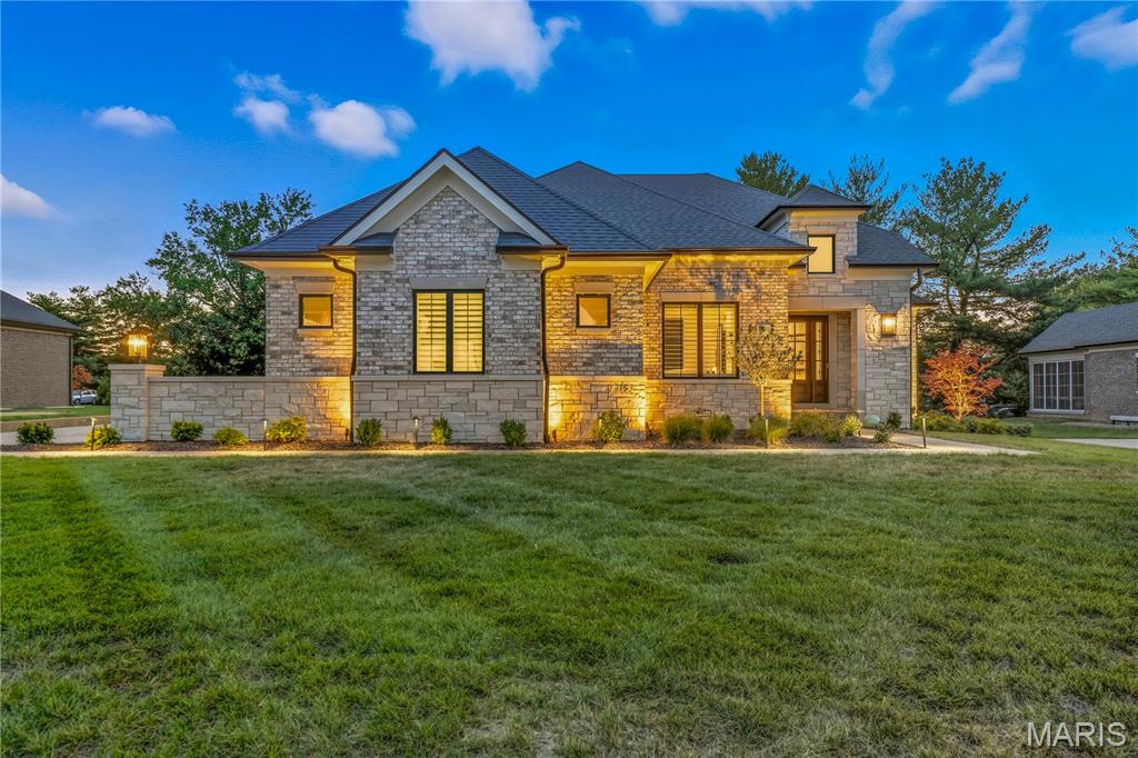 Step into elevated elegance with this masterfully designed residence, where full brick and stone masonry grace a meticulously landscaped 0.4-acre lot. A custom vaulted rear porch—complete with ceiling speakers, a mounted TV, and aggregate flooring—creates a seamless indoor-outdoor experience, while the 3-car side-entry garage features designer doors and a Level 2 EV charger for modern convenience.

Inside, soaring 10’+ ceilings, 8’ solid-core doors, and wide-plank European oak flooring set the stage for sophisticated living. The spacious entry foyer welcomes with grandeur.
The great room impresses with a beamed tray ceiling and a marble fireplace framed by expansive windows. The chef’s kitchen is a showpiece, boasting custom cabinetry, a quartzite island, Sub-Zero and Wolf appliances, a hidden pantry, and dazzling crystal lighting. A sunlit dining area with a wall of windows and a bonus room with piano add charm and versatility. 

The primary suite is a private retreat, featuring a wood-lined tray ceiling, French doors opening to the patio, and a custom walk-in closet. Its spa-inspired bath offers double vanities with quartz counters, a whirlpool tub, heated porcelain floors, and a glass-enclosed rain shower. A separate guest suite provides comfort and style with its own elegant bath and bespoke finishes.

Smart home technology enhances every corner, including Ecobee thermostats, LeGrand lighting, Ring security, and zoned irrigation. The finished lower level adds over 1,700 sq ft of refined space, complete with a bar/kitchenette, Bosch and Zephyr appliances, two bedrooms with walk-in closets and custom egress ladders and a full bath—all bathed in natural light and upscale finishes.

Additional luxuries include crystal chandeliers throughout, incredible array of lighting,  custom built-ins, smart switches, and zoned HVAC with dual water heaters. Every detail of this home reflects a harmonious blend of classic beauty and modern innovation.