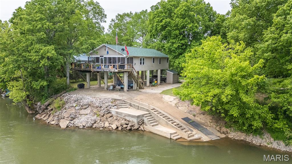 Welcome to Patriots Point—your private slice of paradise on the Current River. With over 200 feet of river frontage, the views are absolutely breathtaking and set the stage for true waterfront living. Your 3 bed, 2 bath home features a bright, open floor plan that flows effortlessly, perfect for gathering with family and friends. The screened-in porch opens onto a deck overlooking the river, creating the perfect space to relax and take in the views. Enjoy easy access to the water with your own private boat ramp. Recent upgrades include a new roof and deck railing, while added features like a Generac generator, outdoor lift/elevator, and owned propane tank provide comfort and convenience. Inside, you’ll enjoy a cozy gas fireplace, gas heat, central vacuum, and a propane tankless water heater. The spacious primary suite includes a spa-like bathroom with a large jetted tub, double vanities, and a separate shower—ideal for unwinding after a day outdoors. A separate RV hookup offers flexibility for guests. Whether you're looking for a full-time home or a weekend getaway, Patriots Point delivers unmatched views, access, and lifestyle.  Call today, before gone tomorrow!!