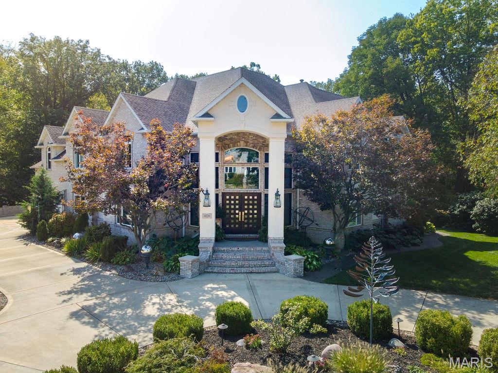 California Coastal in the Midwest: Stunning 5 bed, 8 bath, 2-story in Sunset Hills Estates, completely transformed with a sophisticated high-end rebuild in 2016. A custom mahogany front door opens to a grand foyer with oxidized tiles, curved staircase, and RH crystal/metal chandelier. The living area is anchored by a soaring 20’ vintage Douglas Fir timber. Chef’s kitchen boasts Danby marble countertops and island with Subzero, Wolf, and Miele appliances.  The main-level primary suite is entered through twin 8’ antique doors, with leather plank flooring and a large-scale gas fireplace. Spa-inspired bath offers a freestanding soaking tub, Italian mosaic steam shower, and a must be seen boudoir. The upper level includes: 3 ensuite bedrooms with walk-ins, an open office with built-ins, and a wine loft with lounge and commercial-grade, glass-walled 1000-bottle storage. The multi-walkout lower level includes a 2-level theater, entertaining area with wet bar/kitchenette, 2 full baths, guest suite, laundry, bonus room, exercise room, & workshop. Outdoor living area features a covered Trex deck with spiral staircase to a covered epoxy patio & hot tub. Landscape lighting enhances the private backyard. Only 20+ miles to downtown STL & airport!