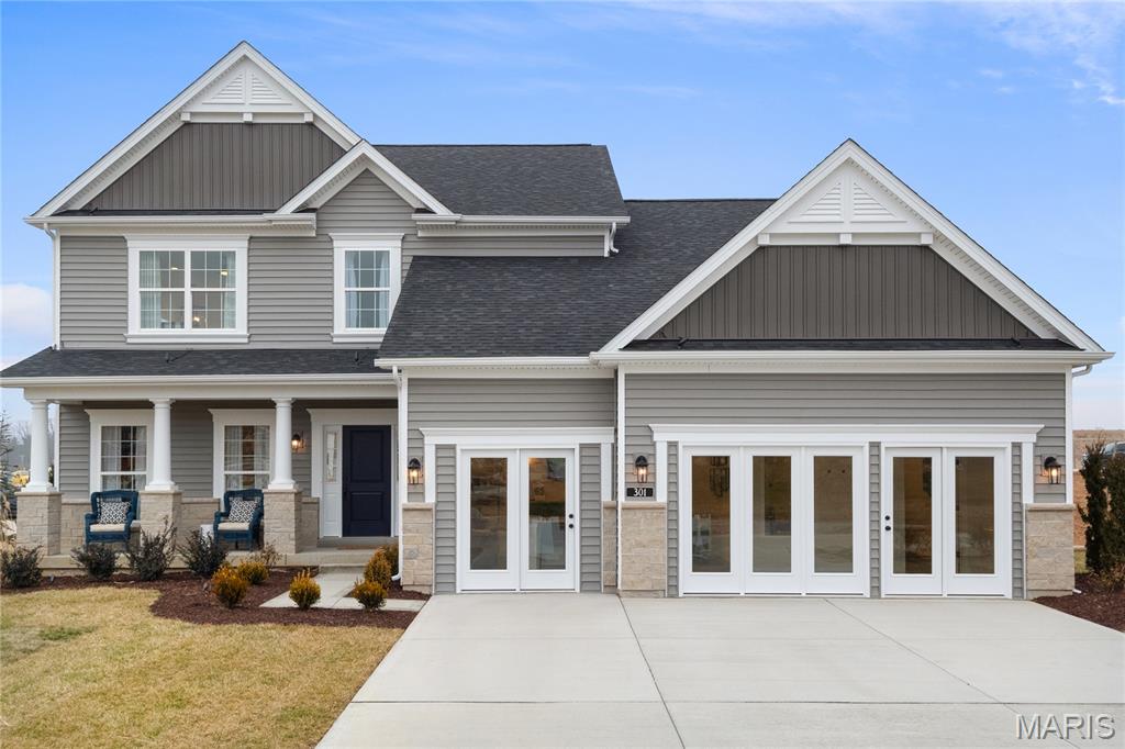 This property is a featured Consort Homes display, built using the highly desirable Extended Bridgeport plan, located in The Reserve at Lakeview Farms within the highly acclaimed Francis Howell R III School District. This impressive 1.5 story Craftsman style residence offers 3,204 sq ft of thoughtfully designed living space with 4 bedrooms, 4.5 baths, and a 3 car attached garage. The main level showcases an open and inviting family room highlighted by a gas fireplace, window wall, and ceiling fan, creating a bright and welcoming atmosphere. The luxury kitchen is designed for both everyday living and entertaining, featuring quartz countertops, stainless steel gas appliances, refrigerator, two tone staggered cabinetry with glass mullion accents, crown molding, decorative panels, roll out trays, refrigerator cabinet, and stylish hardware. Adjacent breakfast and separate dining rooms provide flexible dining options. The main floor primary suite serves as a private retreat with a 10 foot ceiling, ceiling fan, walk in closet, and a beautifully appointed bath featuring a double wave bowl vanity and a freestanding soaking tub. A main level laundry room with cabinetry and Granite countertops and half bath add convenience to the primary living level. The upper level includes a bonus room with ceiling fan, three additional bedrooms with bracing for future ceiling fans, and two full baths, including a shared bath with a double wave bowl vanity. Interior features include laminate, carpet, and luxury vinyl flooring, quartz countertops throughout, a smart thermostat, and dual zoned HVAC for enhanced energy efficiency. The full inground basement offers 8 foot ceilings, an egress window, sump pump, and an unfinished area  with full bath — providing excellent potential for future living space.